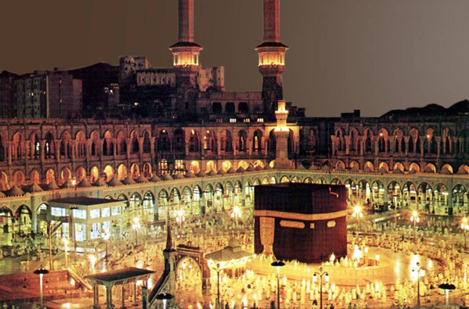 Makkah 桌布 壁紙 — 麥加卡巴天房的夜間航拍圖，金色燈光照亮，數千朝聖者繞行。