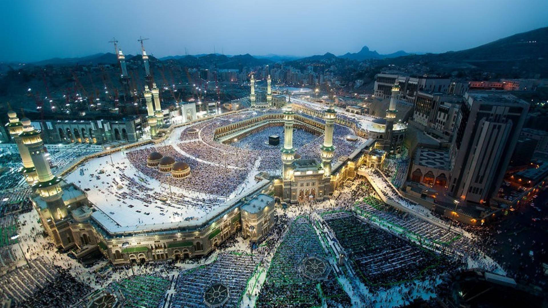 Makkah 桌布 壁紙 — 麥加大清真寺在黃昏時的鳥瞰圖，數百萬朝聖者在溫暖的金色燈光下繞行卡巴天房。