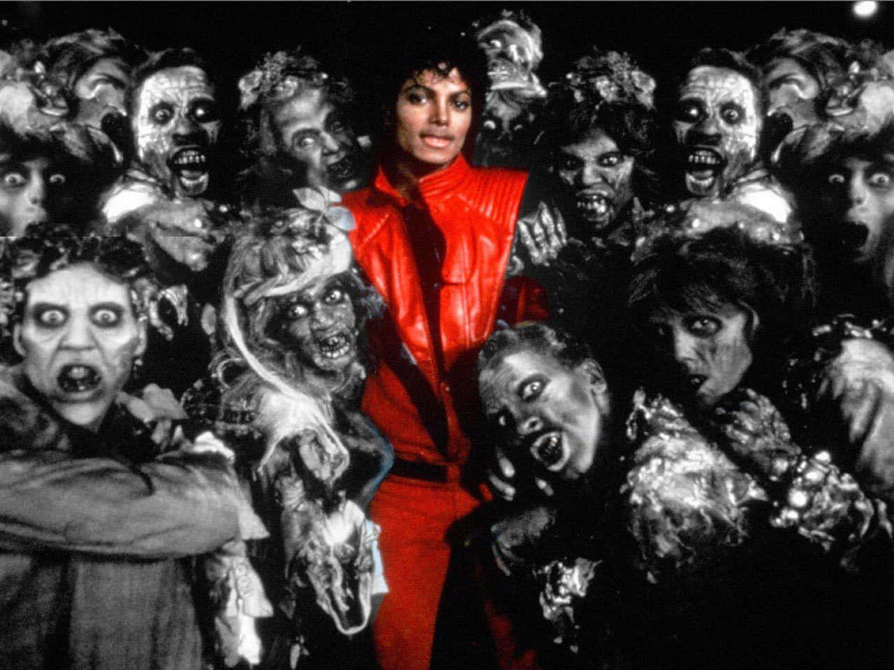 Michael Jackson Thriller 桌布 壁紙 — 麥可傑克森穿著搶眼的紅色服裝，站在舞台中央，被一群怪誕的殭屍般人物包圍，形成高對比度的黑白場景。