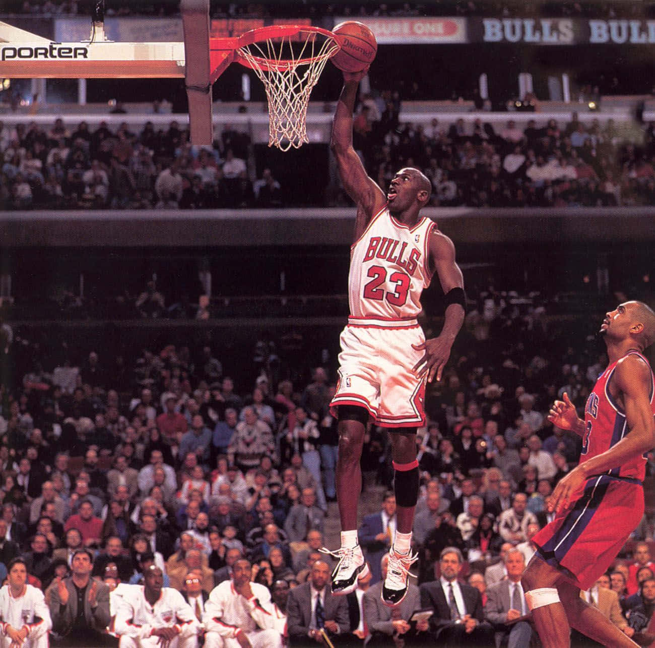 Michael Jordan Dunk 桌布 壁紙 — 麥可喬丹在滿座的芝加哥公牛球場，於一場高風險比賽中飛越籃框大力灌籃。