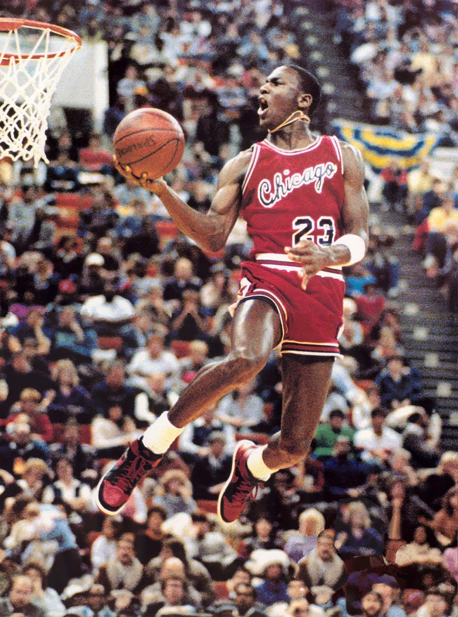 Michael Jordan Dunk 桌布 壁紙 — 麥可喬丹穿著標誌性的紅色芝加哥球衣在空中翱翔，在咆哮的人群上方扣籃。