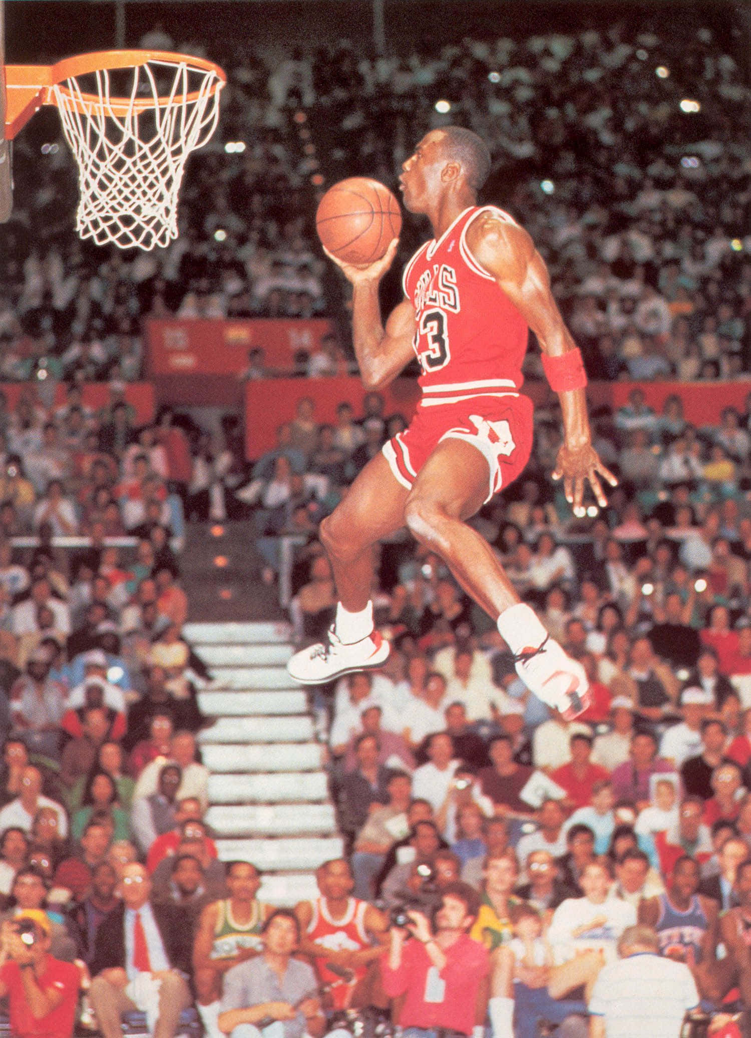 Michael Jordan Dunk 桌布 壁紙 — 麥可喬丹穿著紅色芝加哥公牛隊球衣，在擠滿觀眾的球場比賽中騰空而起準備灌籃。