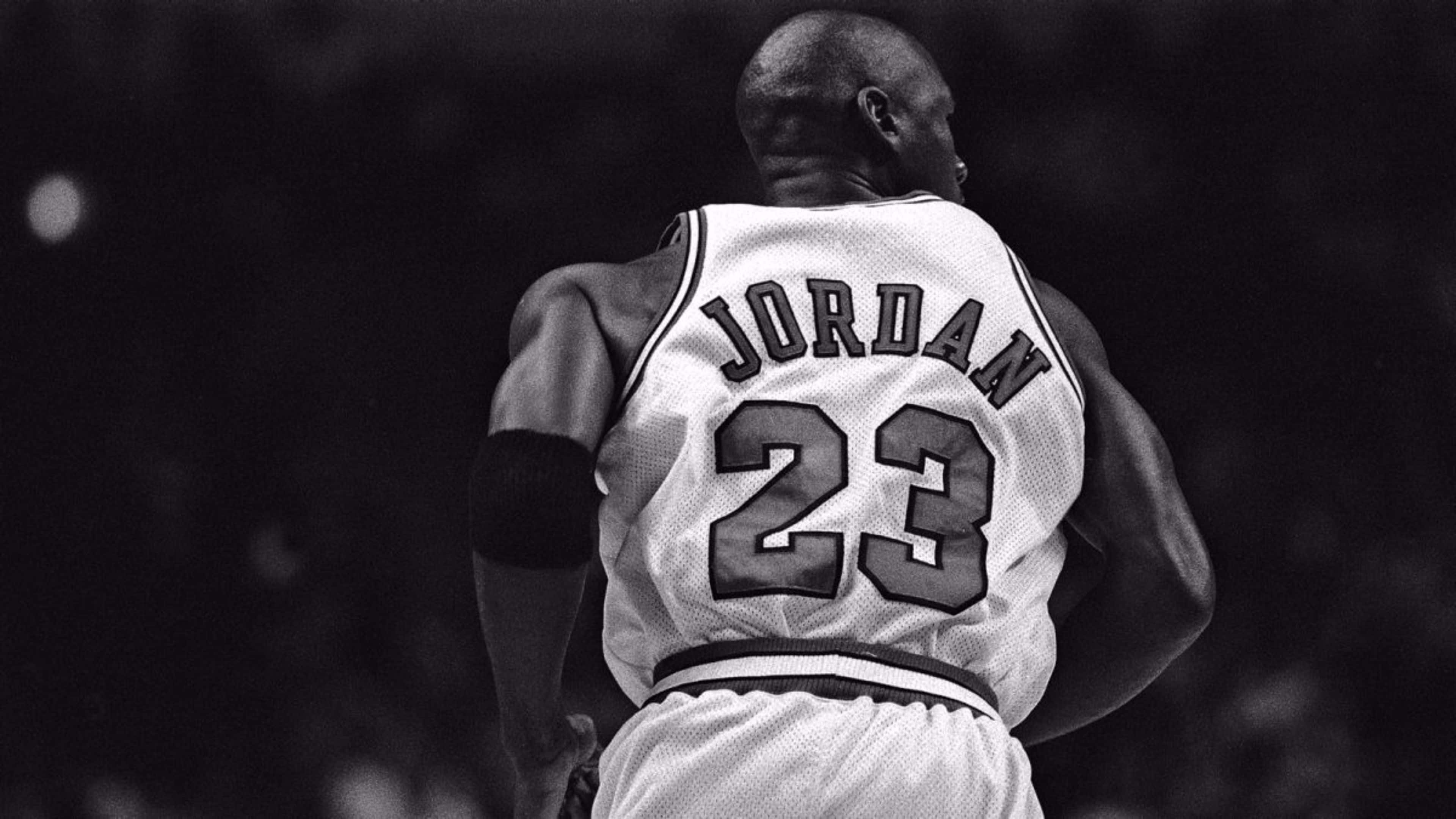 Jordan 桌布 壁紙 — 麥可喬丹身穿標誌性23號球衣的背影，在籃球比賽中以戲劇性的黑白效果捕捉。