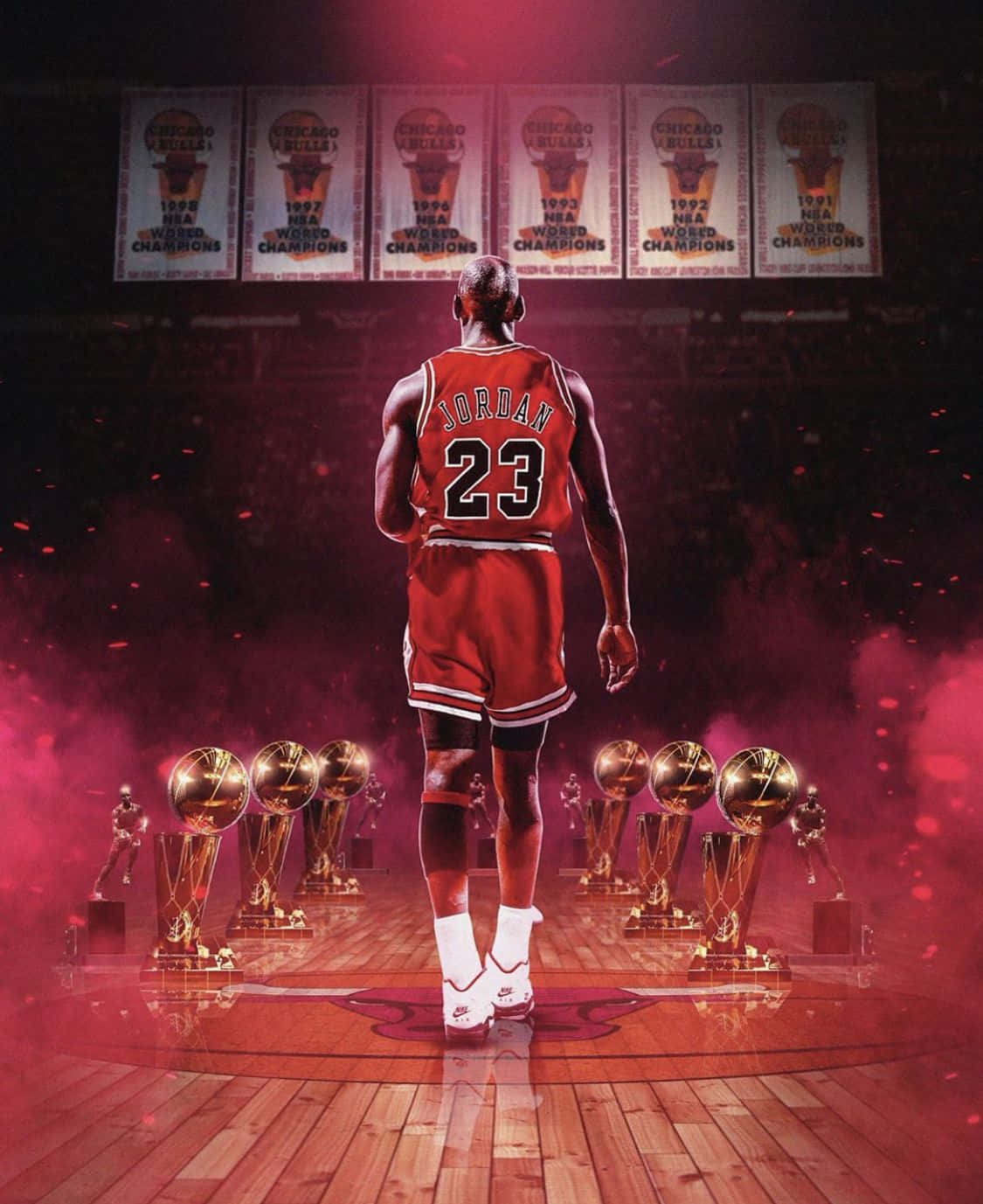 麥可喬丹身穿紅色球衣站在球場上，周圍環繞著NBA冠軍獎盃。 — Michael B Jordan 壁紙