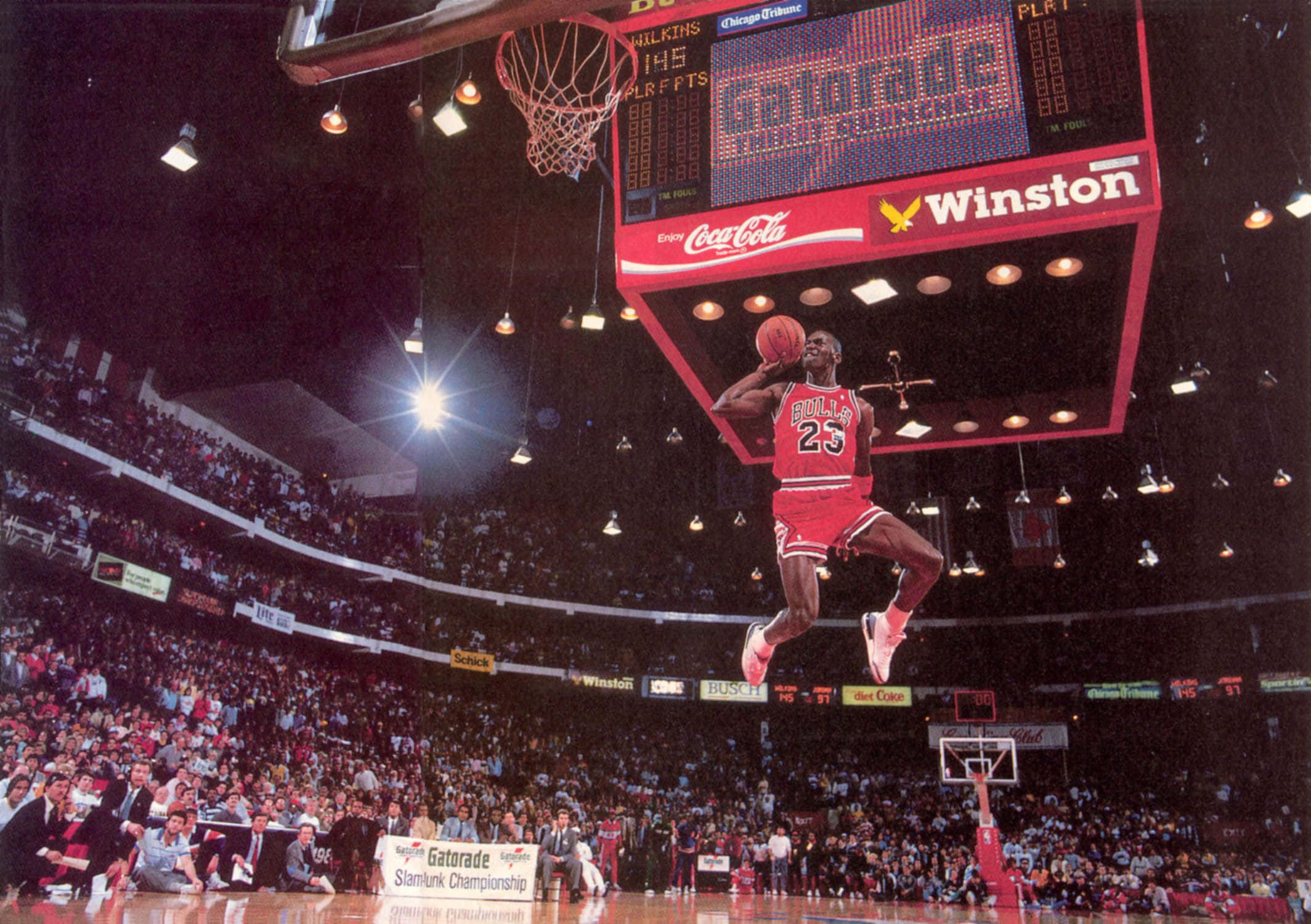 Michael Jordan Dunk 桌布 壁紙 — 麥可喬丹身穿芝加哥公牛隊紅色球衣，在1996年灌籃大賽中飛身灌籃。
