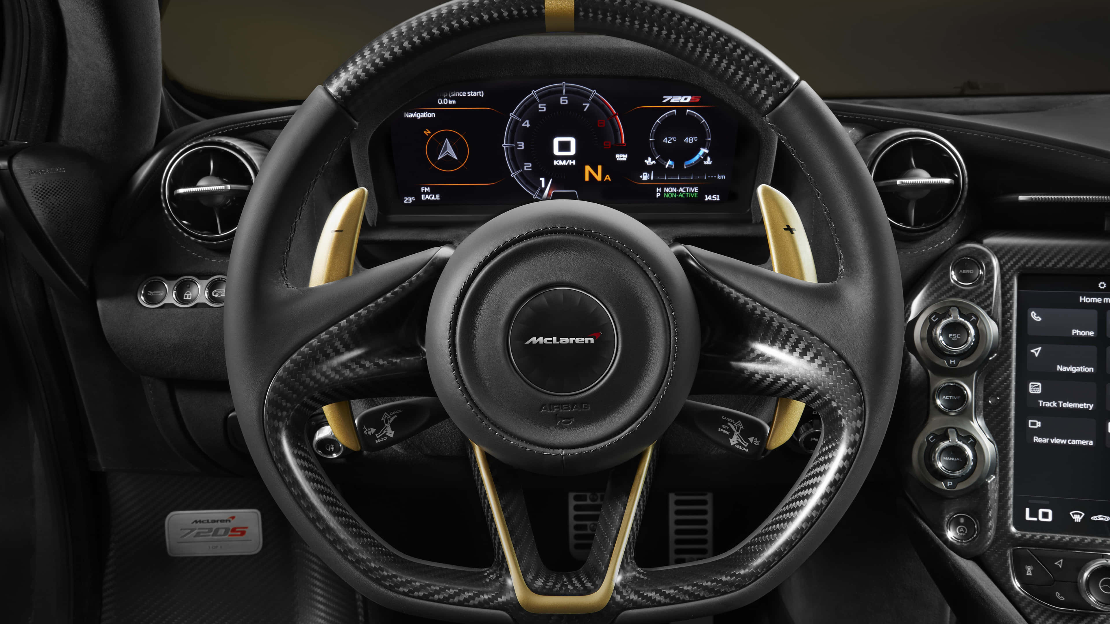 4K Mclaren 720s 桌布 壁紙 — 麥拉倫720S跑車內飾特寫，展示碳纖維方向盤配金色裝飾和數位儀表板。