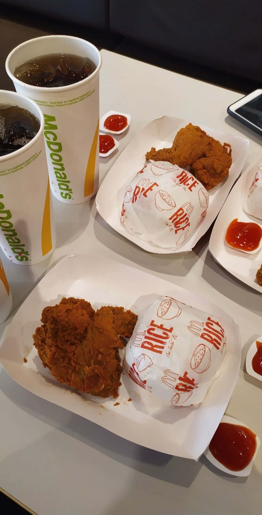 Chicken 桌布 壁紙 — 麥當勞炸雞飯碗和冰涼飲品放在白色桌子上，旁邊有番茄醬包的特寫。