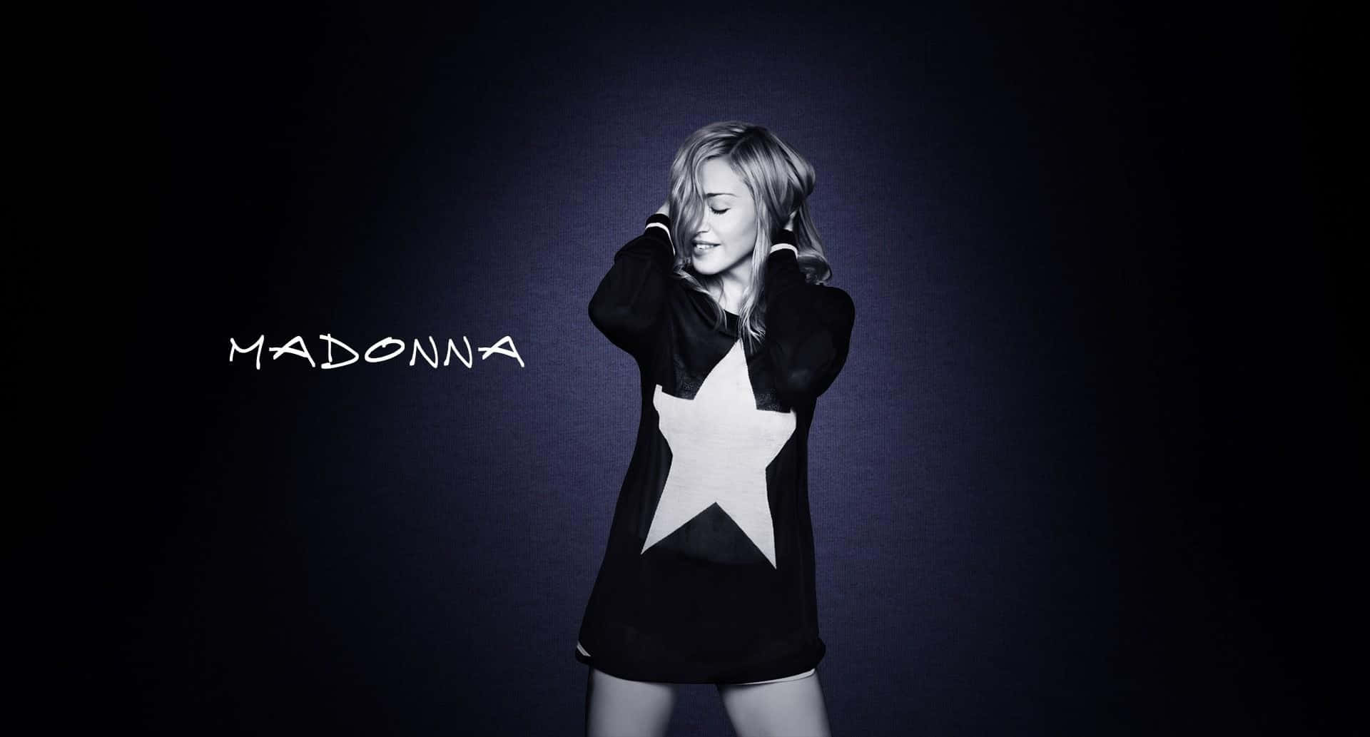 Madonna 桌布 壁紙 — 麥當娜在深色漸變背景前穿著黑色星星印花連帽衫，溫柔微笑，她的名字寫在旁邊。