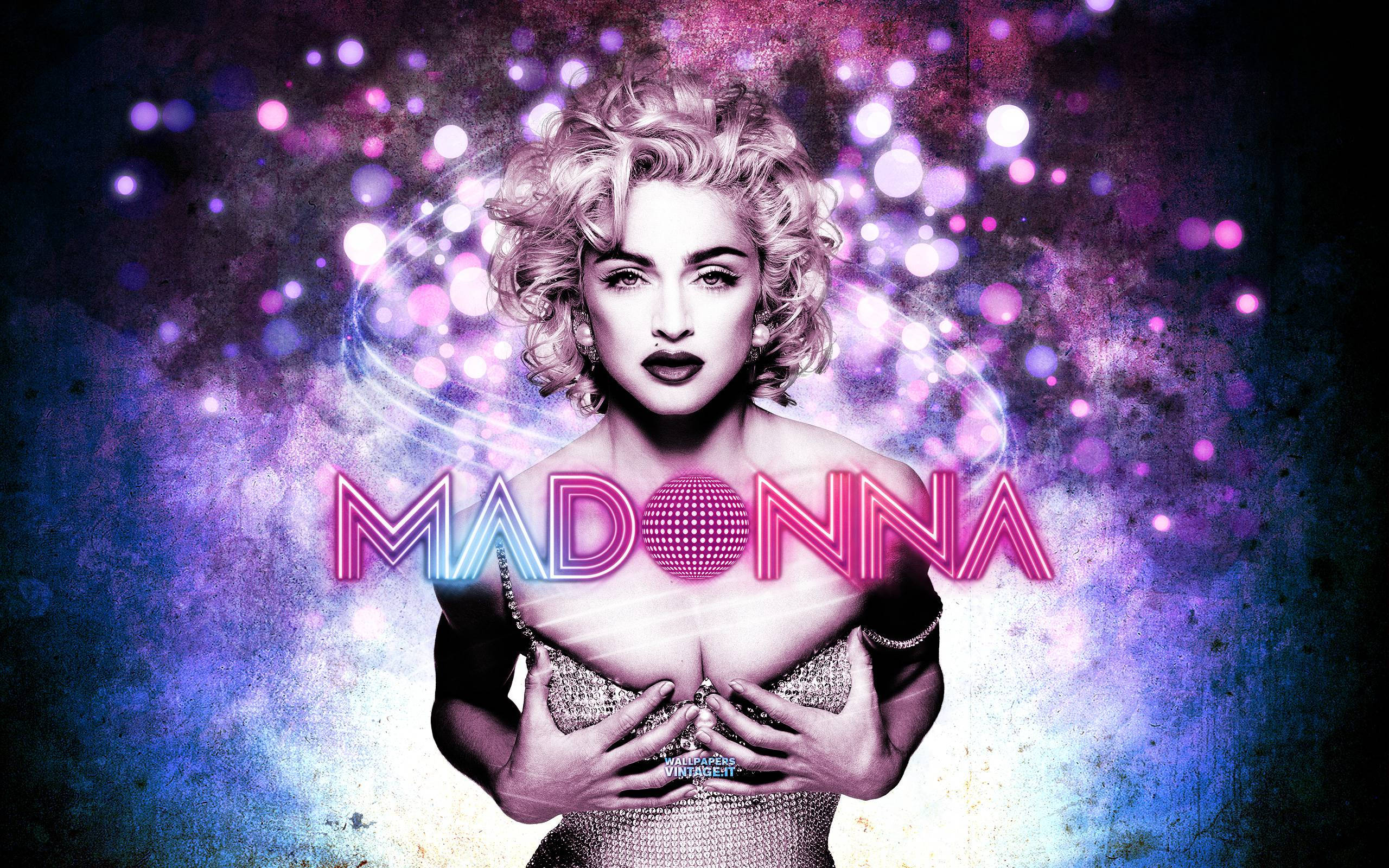 Madonna 桌布 壁紙 — 麥當娜身穿閃亮服裝，在充滿活力的紫色和藍色散景背景中，自信地擺出姿勢，周圍有發光的燈光。