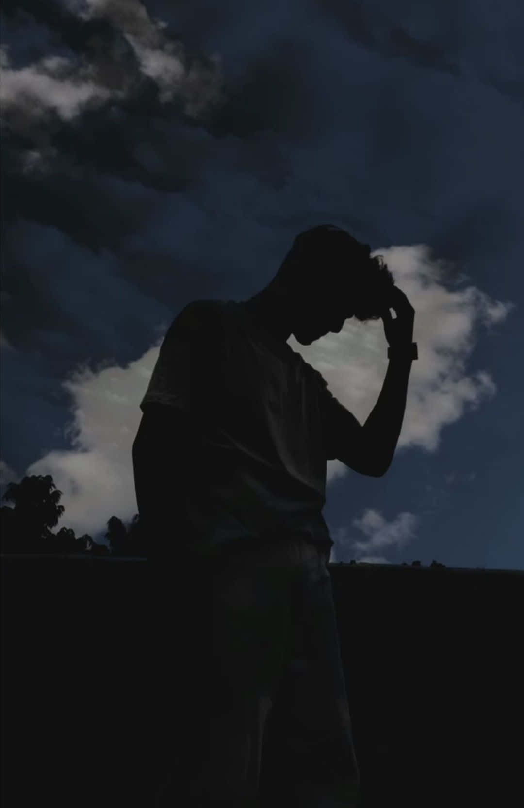 shadow 桌布 壁紙 — 黃昏時分，一個人孤獨的剪影，在戲劇性的多雲天空下抱著頭。