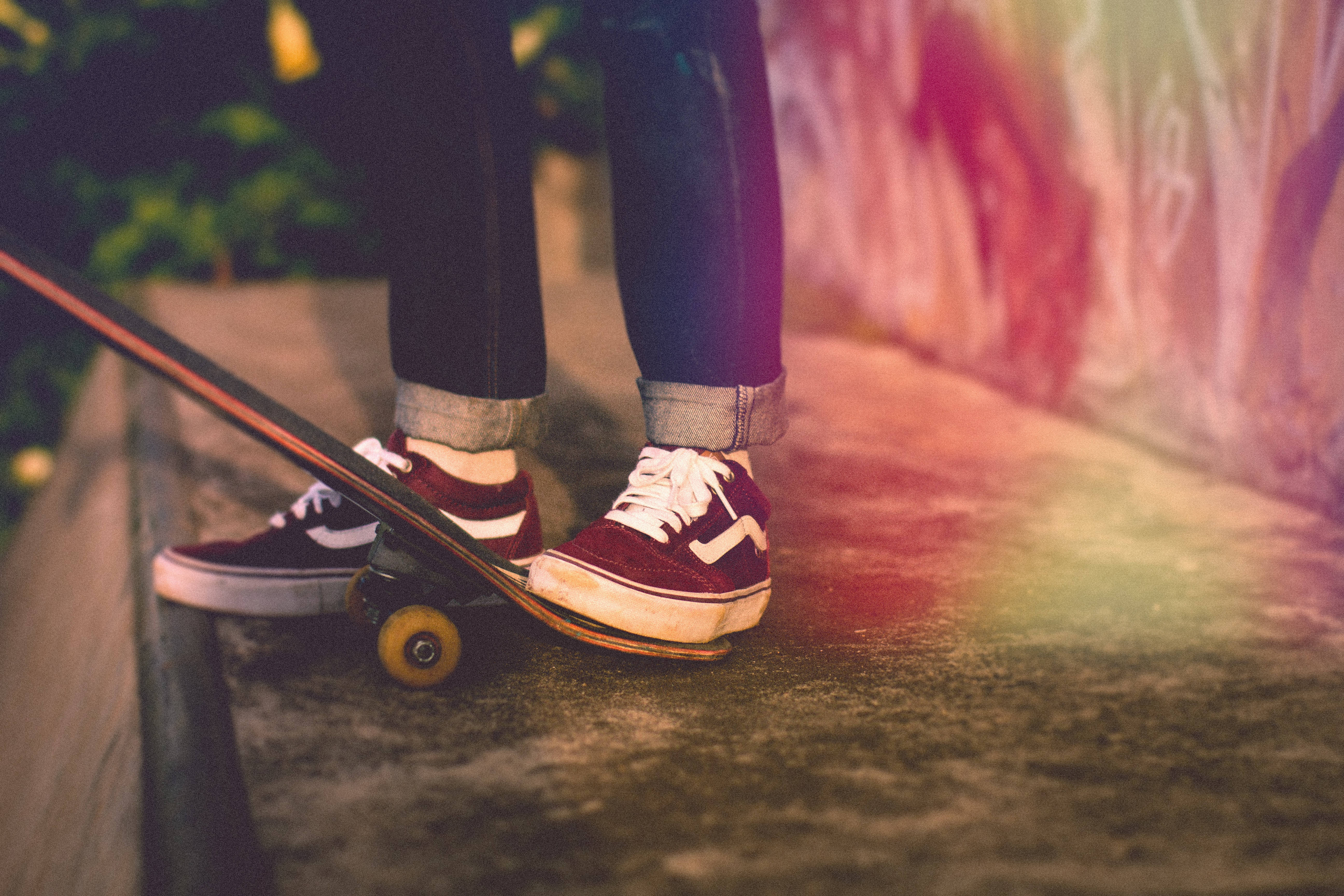 Vans 桌布 壁紙 — 黃昏時分，一個人穿著紅色運動鞋在滑板上平衡，背景是塗鴉牆的特寫。