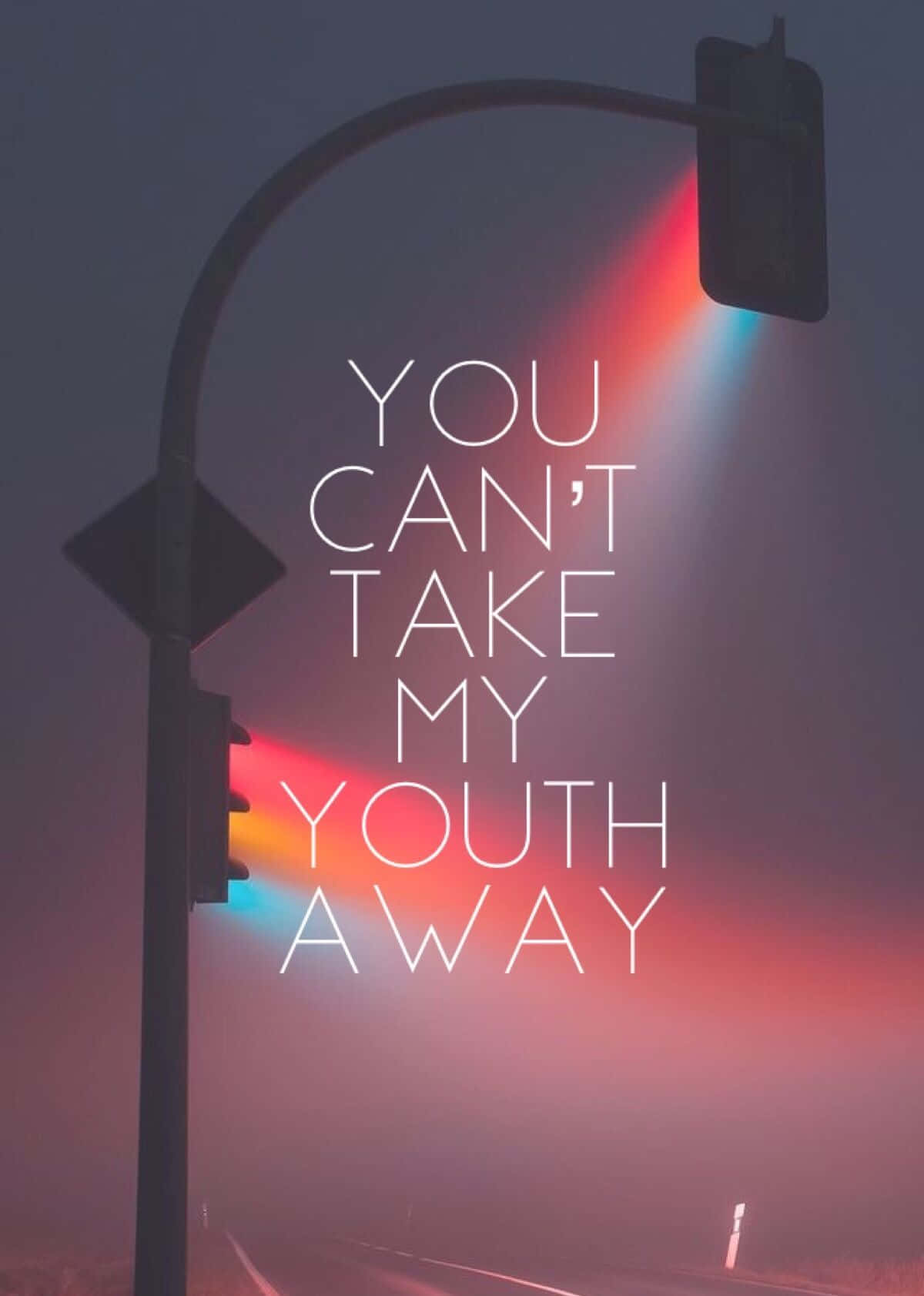 Youthful 桌布 壁紙 — 黃昏時分，一條霧濛濛的街道，交通號誌在粗體白色文字「YOU CAN'T TAKE MY YOUTH AWAY」後方投射出紅色和藍色的光束。