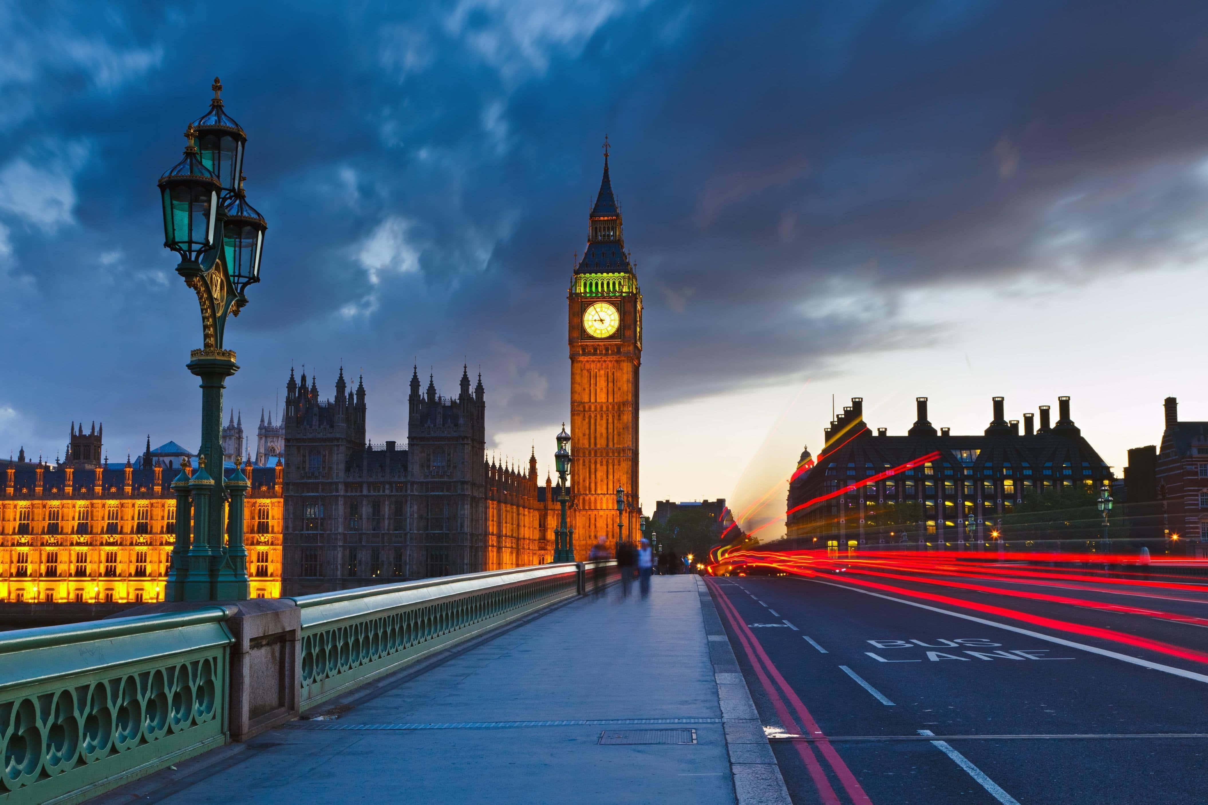 England 桌布 壁紙 — 黃昏時分，大笨鐘和國會大廈亮起燈光，西敏橋上紅色巴士燈光劃過。
