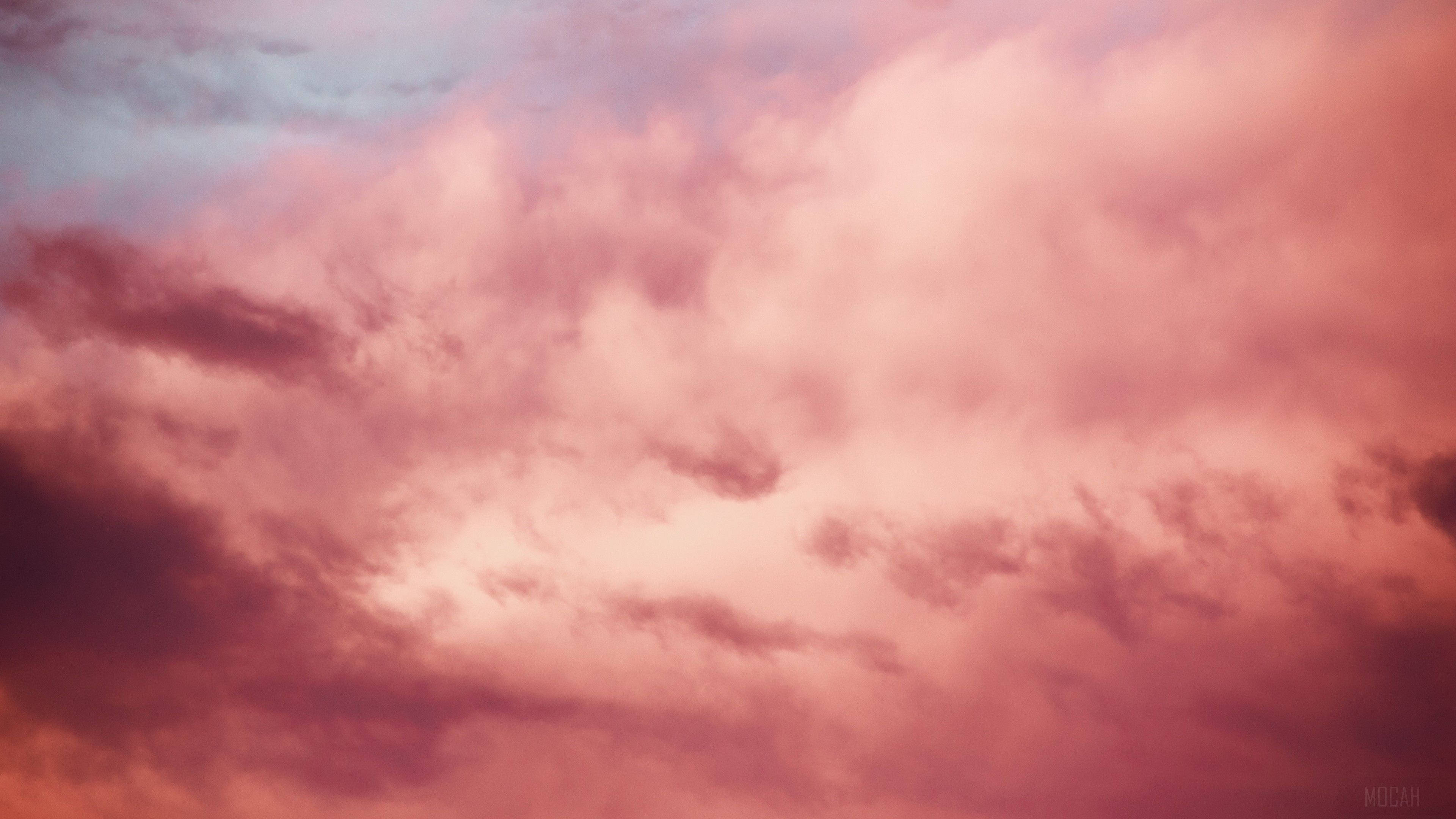 Cloudy Sky 桌布 壁紙 — 黃昏時分，天空充滿柔和粉紅與橙色雲朵，邊緣帶有紫色調，景象壯麗。