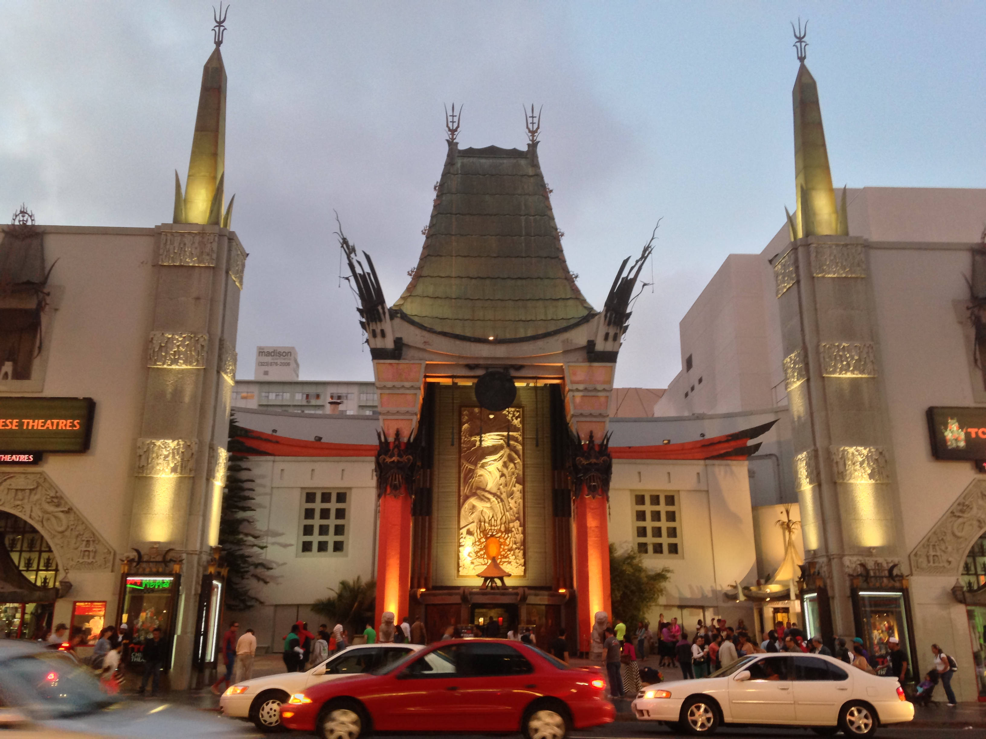 hollywood street 桌布 壁紙 — 黃昏時分，宏偉好萊塢劇院入口燈火通明，人群和汽車穿梭而過。