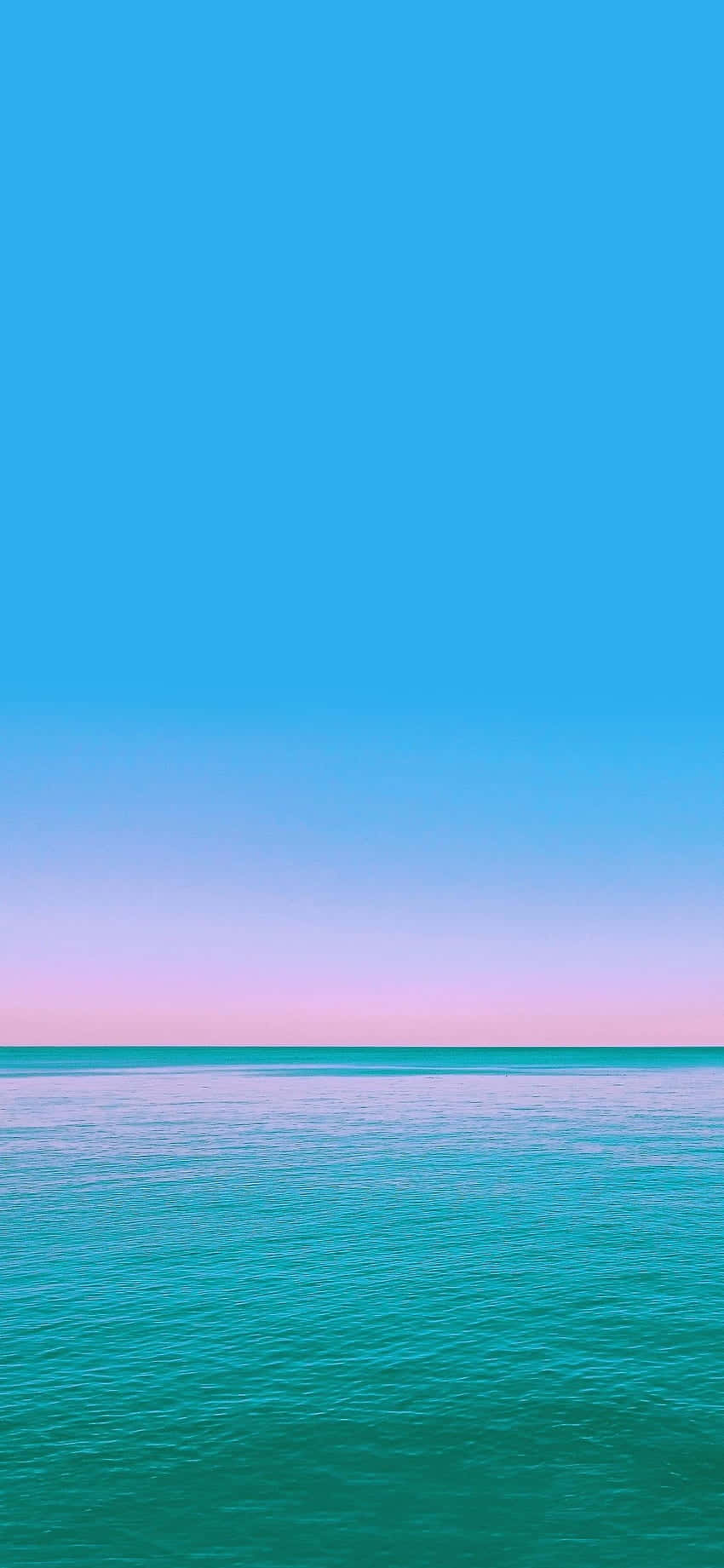 桌布 壁紙 — 黃昏時分，平靜的藍綠色海面上，天空從青色漸變為粉紅色。