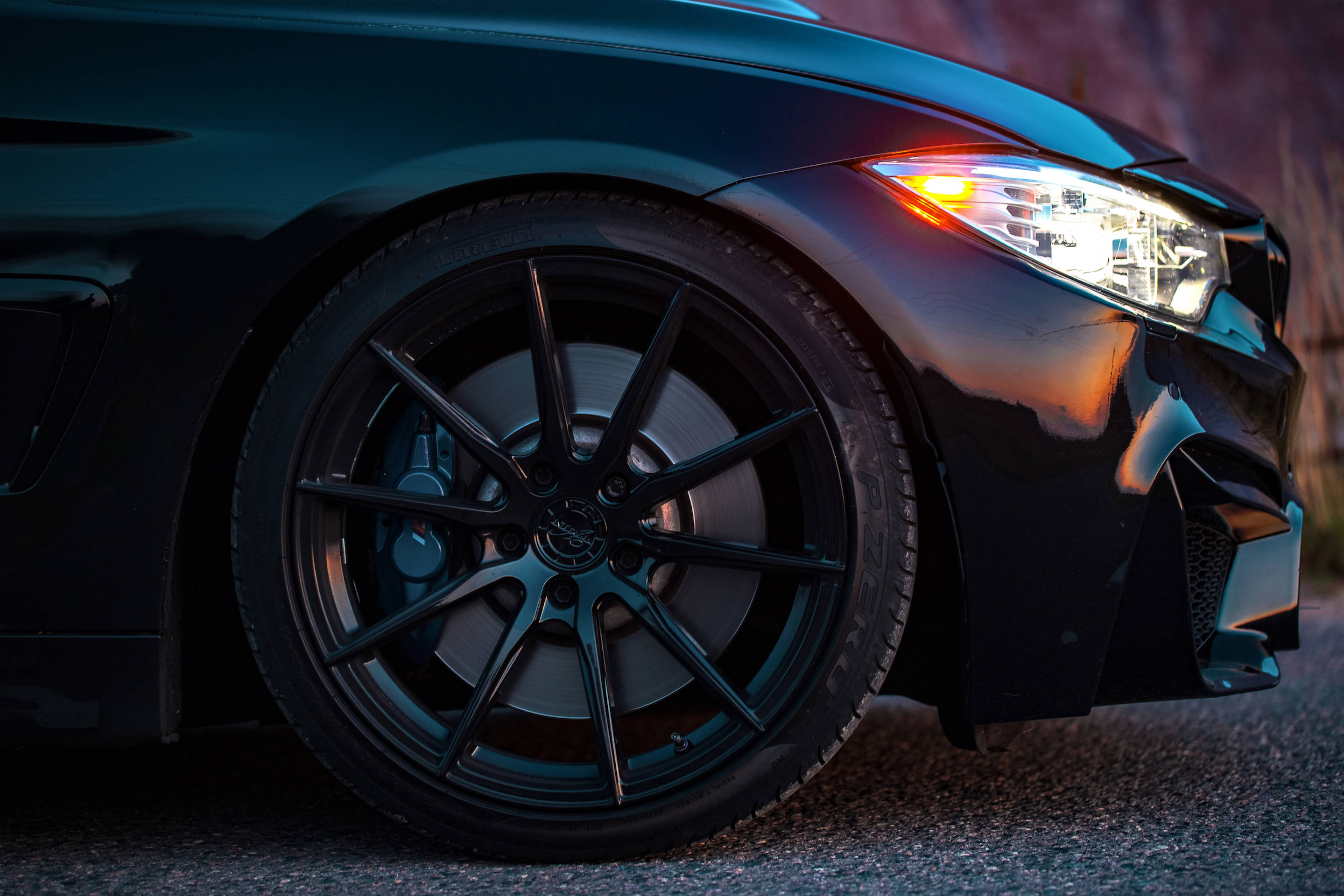 Black Bmw 桌布 壁紙 — 黃昏時分，時尚黑色跑車前輪和發光車頭燈的特寫。