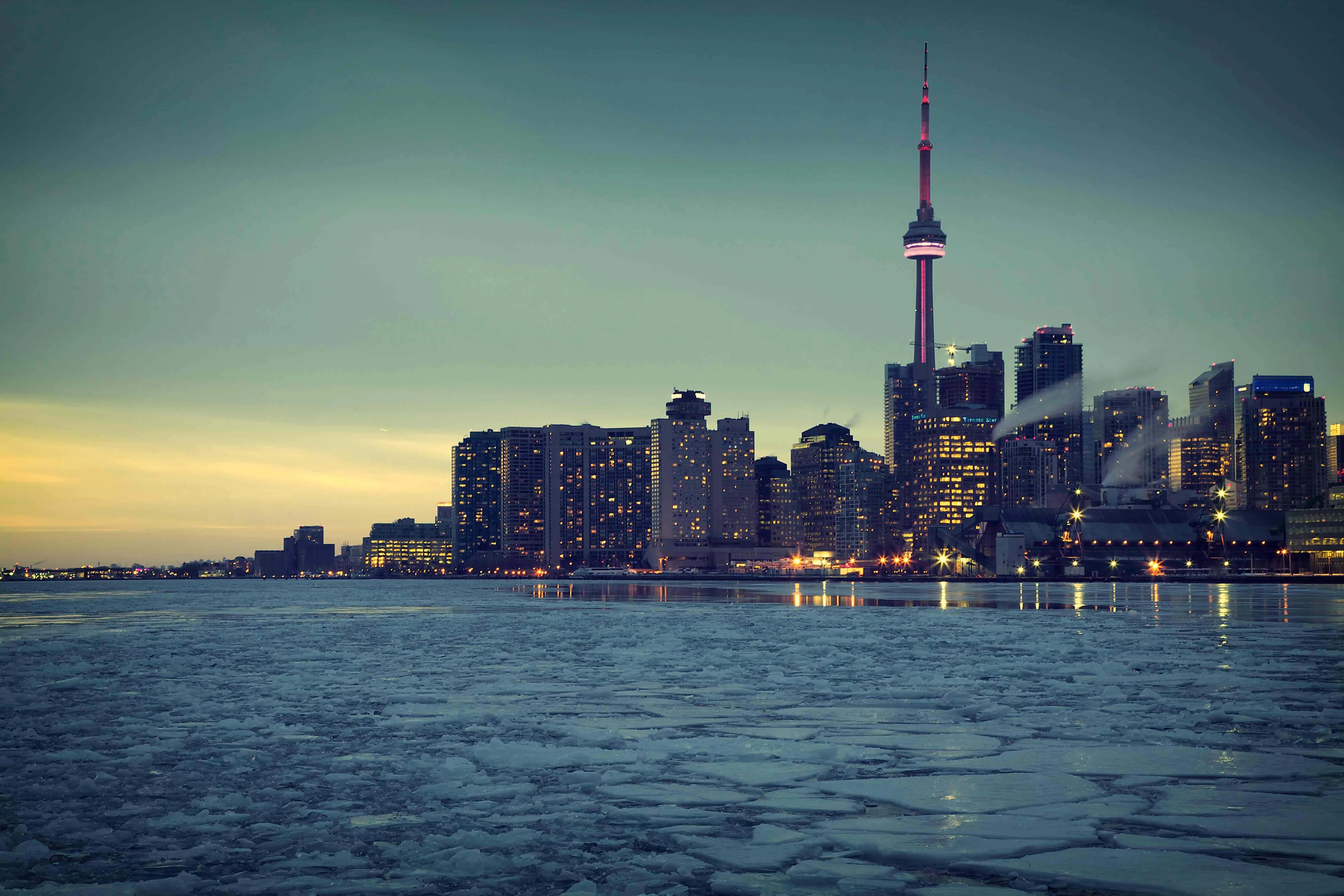 Toronto Skyline 桌布 壁紙 — 黃昏時分，結冰的海濱倒映著多倫多天際線的璀璨燈光，其中以CN塔最為矚目。