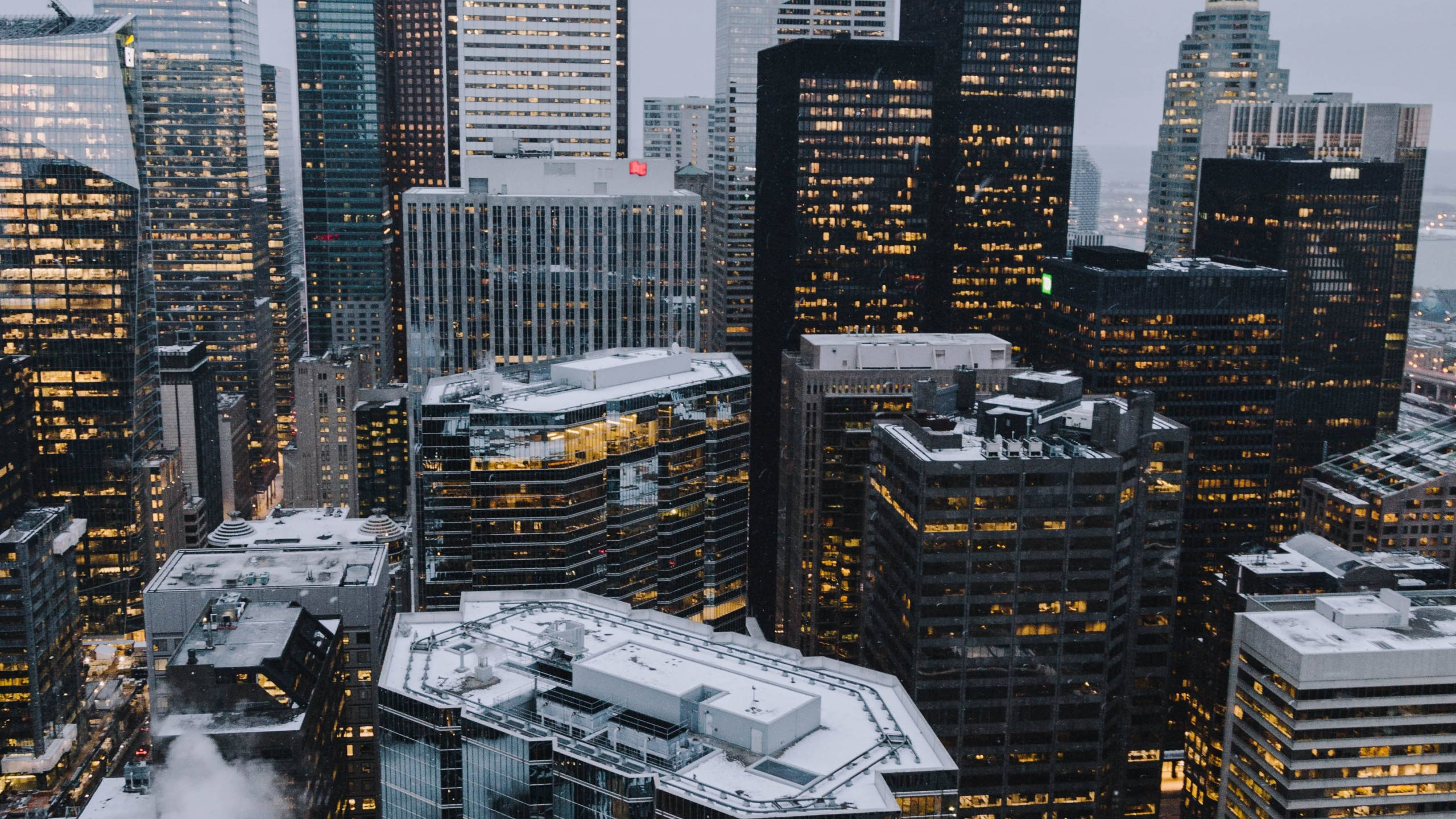Toronto 桌布 壁紙 — 黃昏時分，被雪覆蓋的摩天大樓的鳥瞰圖，灰色天空下窗戶閃爍著光芒。