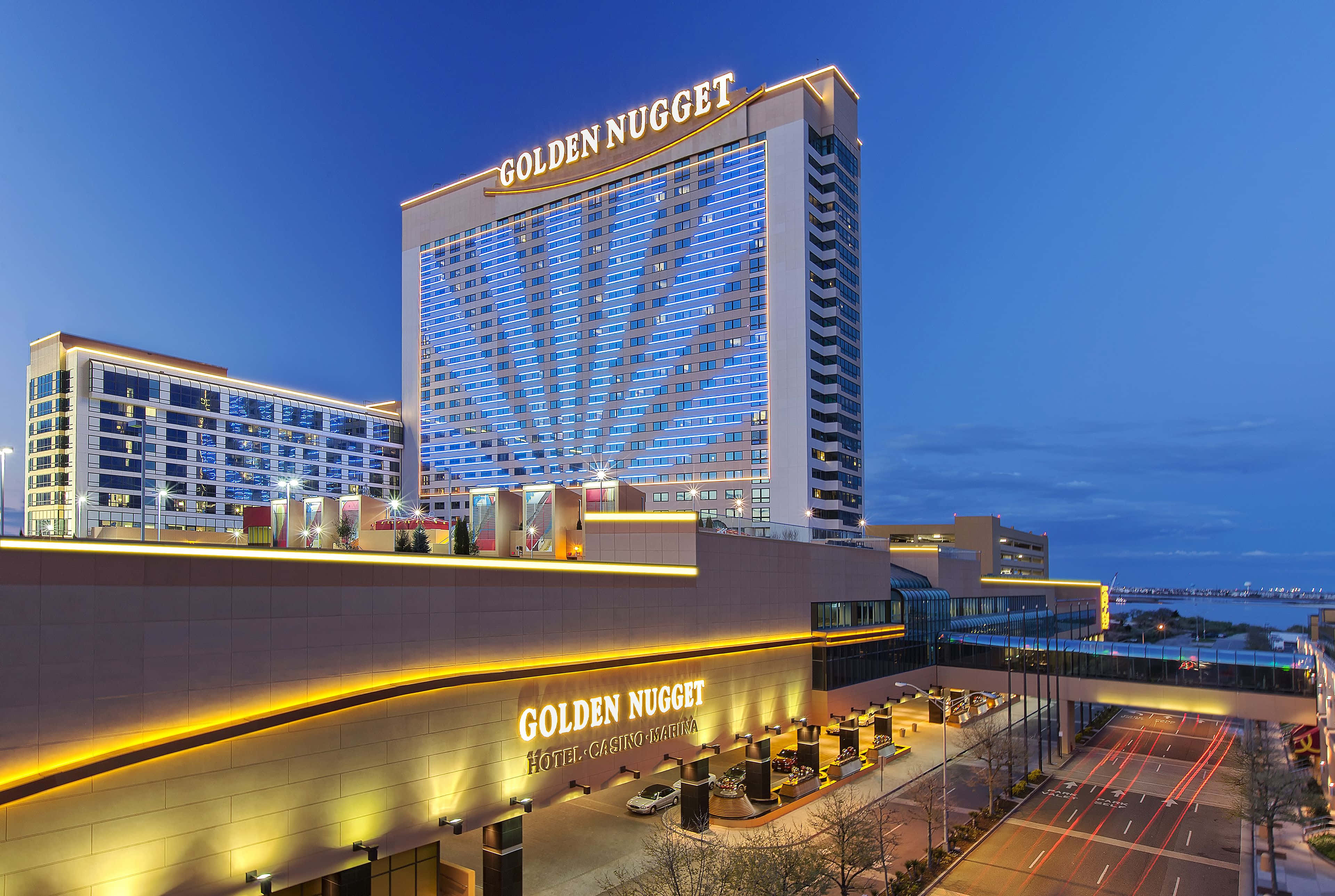 Hotel 桌布 壁紙 — 黃昏時分，金塊酒店賭場亮起燈光，藍色窗戶閃閃發光，金色飾邊映襯著深藍色的天空。