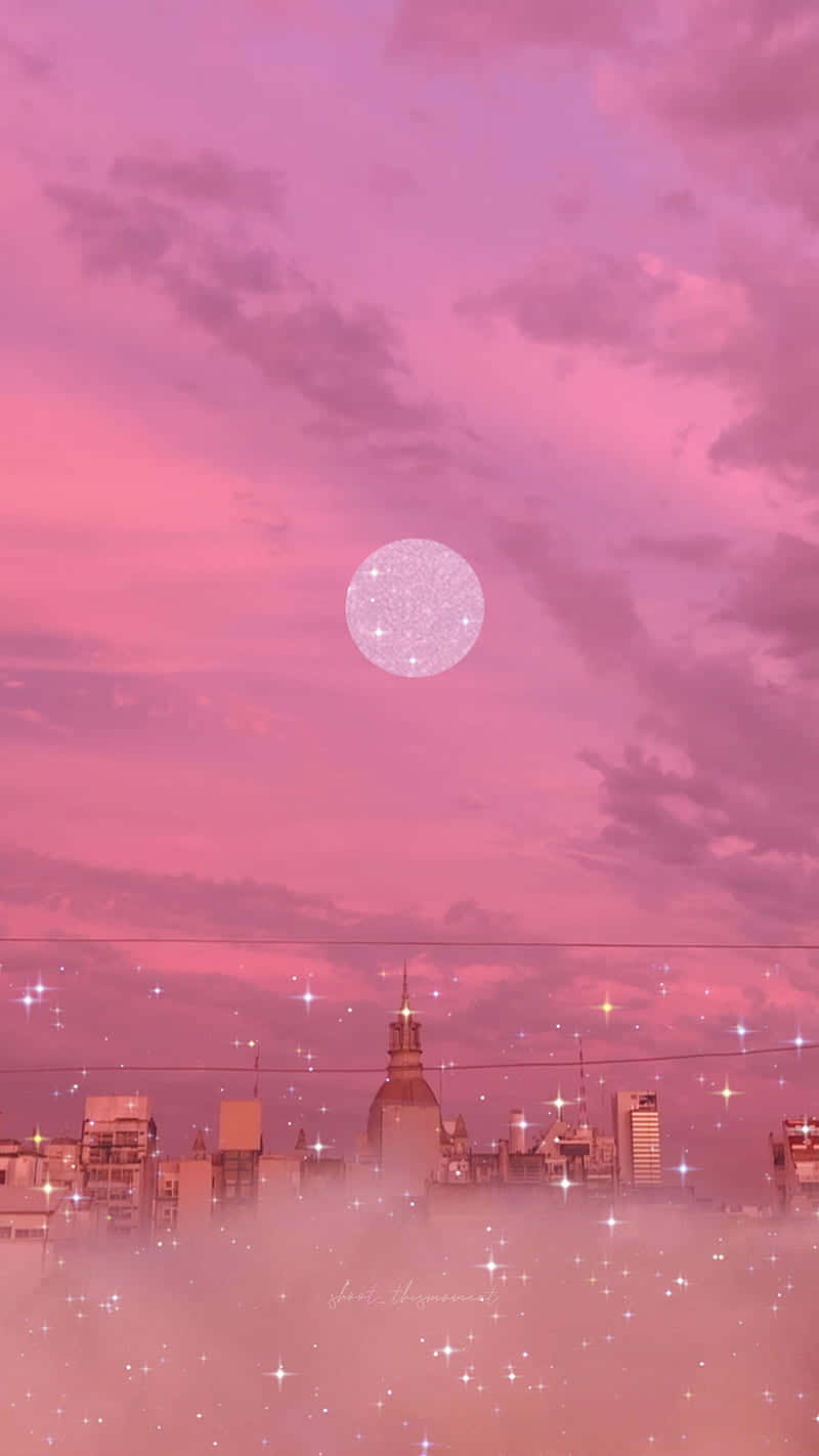 桌布 壁紙 — 黃昏時分，霧氣籠罩的建築物上方，閃爍的月亮和星星點綴著夢幻般的粉紅色城市景觀。