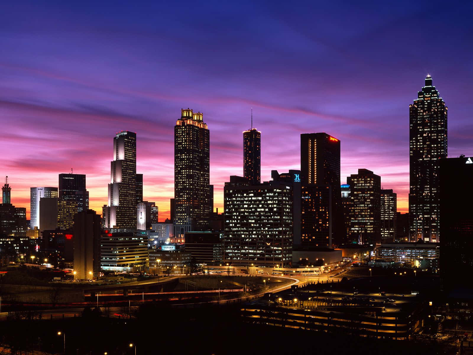 Atlanta Georgia 桌布 壁紙 — 黃昏時分充滿活力的城市天際線，摩天大樓在紫色和粉紅色的天空下閃耀。