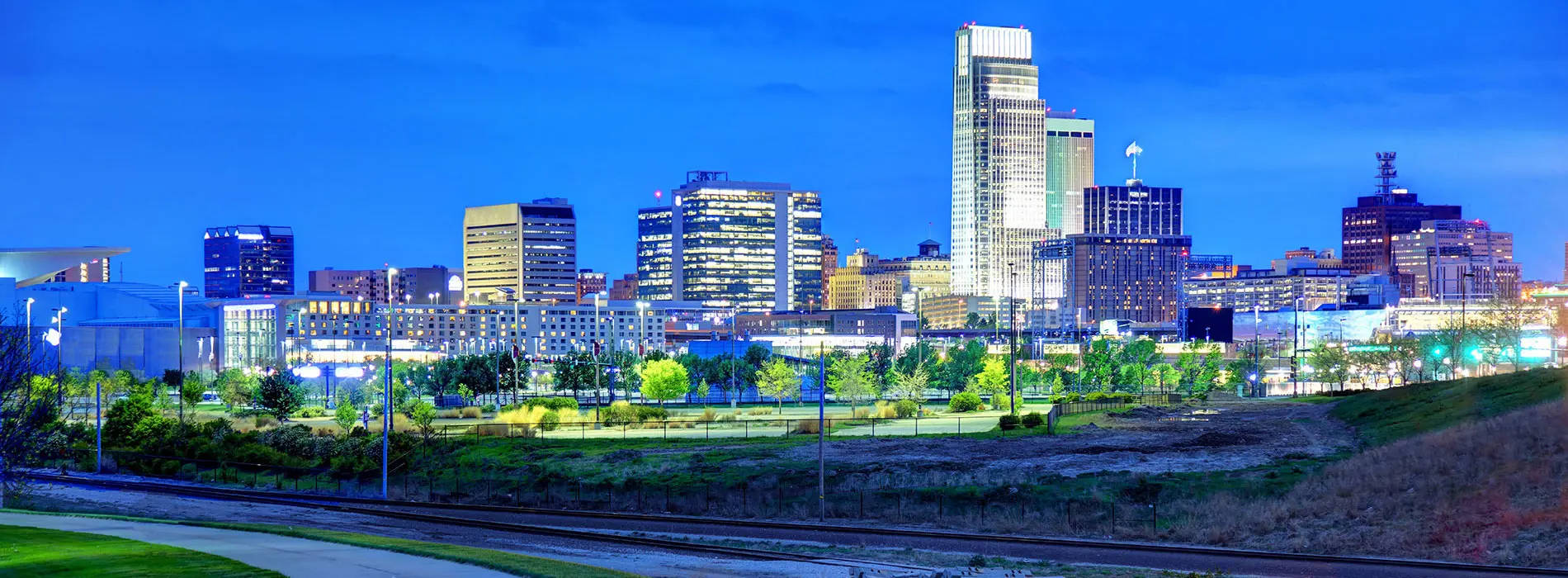 Nebraska 桌布 壁紙 — 黃昏時分充滿活力的城市天際線，摩天大樓在深藍色天空的映襯下閃閃發光。