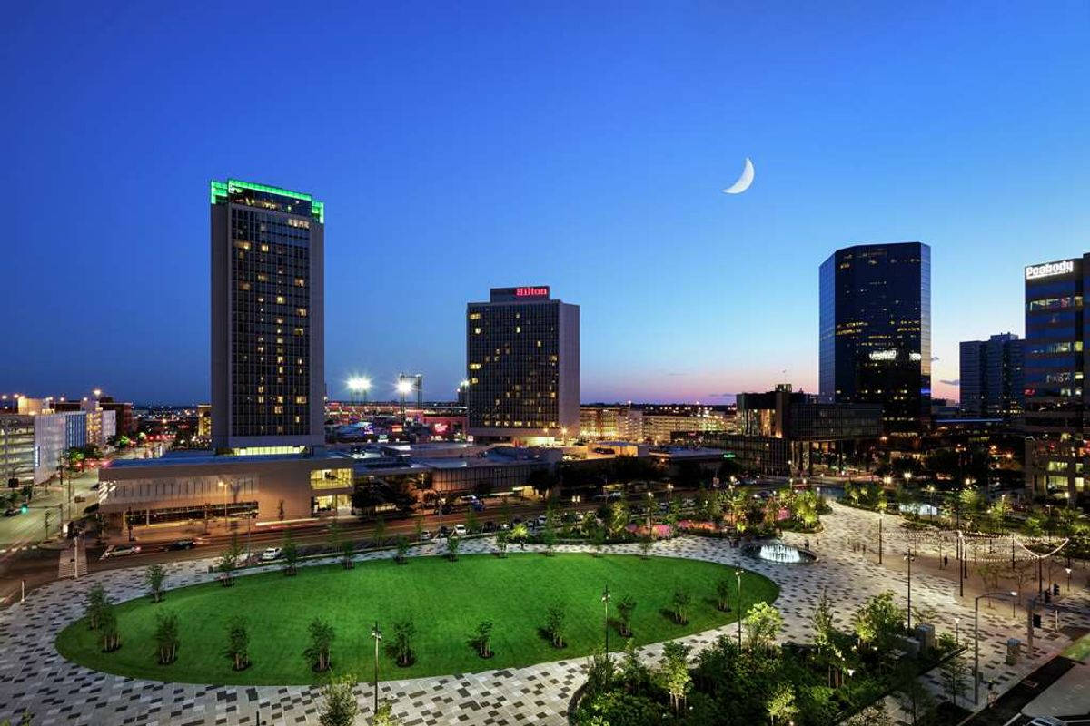 City Night 桌布 壁紙 — 黃昏時分充滿活力的城市天際線，有燈火通明的摩天大樓和綠色公園上方的一彎新月。