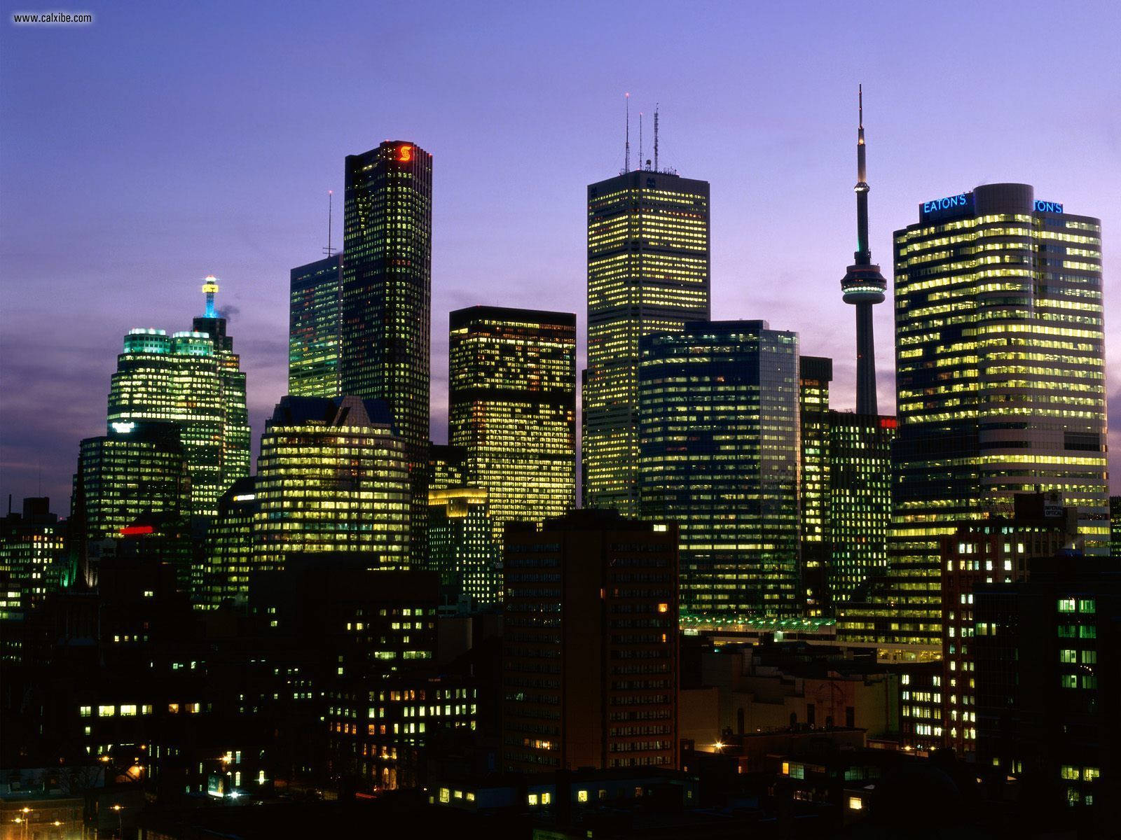 Ontario 桌布 壁紙 — 黃昏時分充滿活力的城市天際線，燈火通明的摩天大樓和標誌性的CN塔在紫色天空下閃耀。
