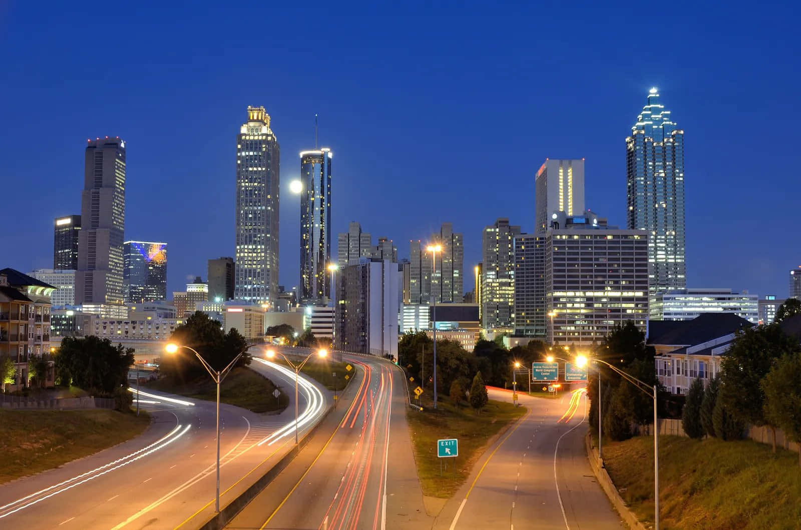 Atlanta Georgia 桌布 壁紙 — 黃昏時分充滿活力的城市天際線，閃爍的摩天大樓和蜿蜒道路上交通的光跡。