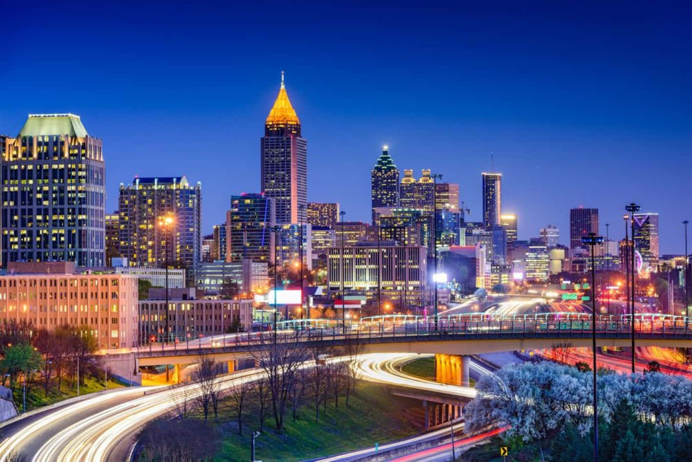 Atlanta Georgia 桌布 壁紙 — 黃昏時分充滿活力的城市天際線，閃爍的摩天大樓和下方交通的光跡。