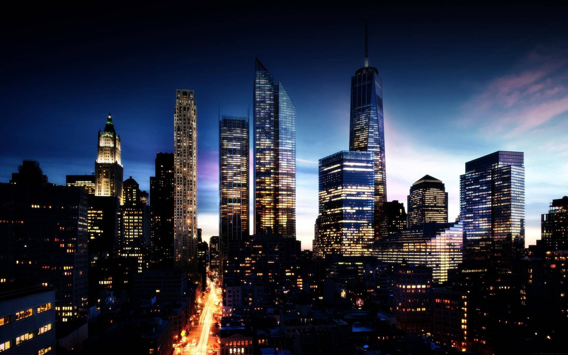 Skyscraper 桌布 壁紙 — 黃昏時分充滿活力的城市天際線，高聳的摩天大樓在深藍色帶有紫色雲彩的天空中閃耀。
