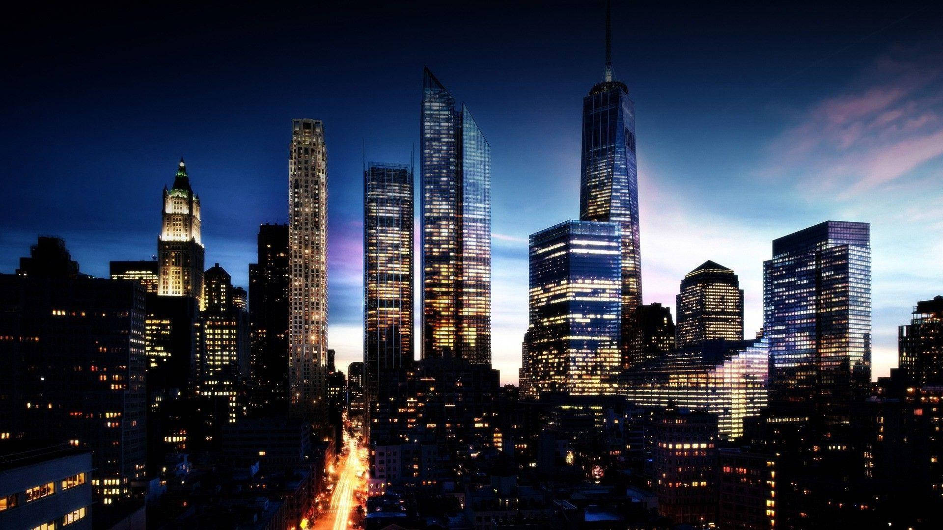 New York 桌布 壁紙 — 黃昏時分充滿活力的城市天際線，高聳的摩天大樓在深藍色天空和紫色雲彩的映襯下閃閃發光。