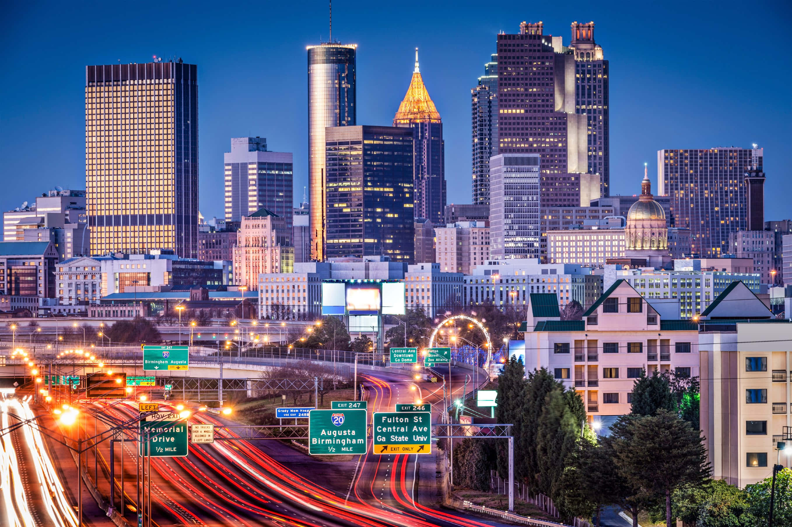 Atlanta Georgia 桌布 壁紙 — 黃昏時分充滿活力的城市景觀，明亮的摩天大樓和繁忙高速公路上的車流光軌。
