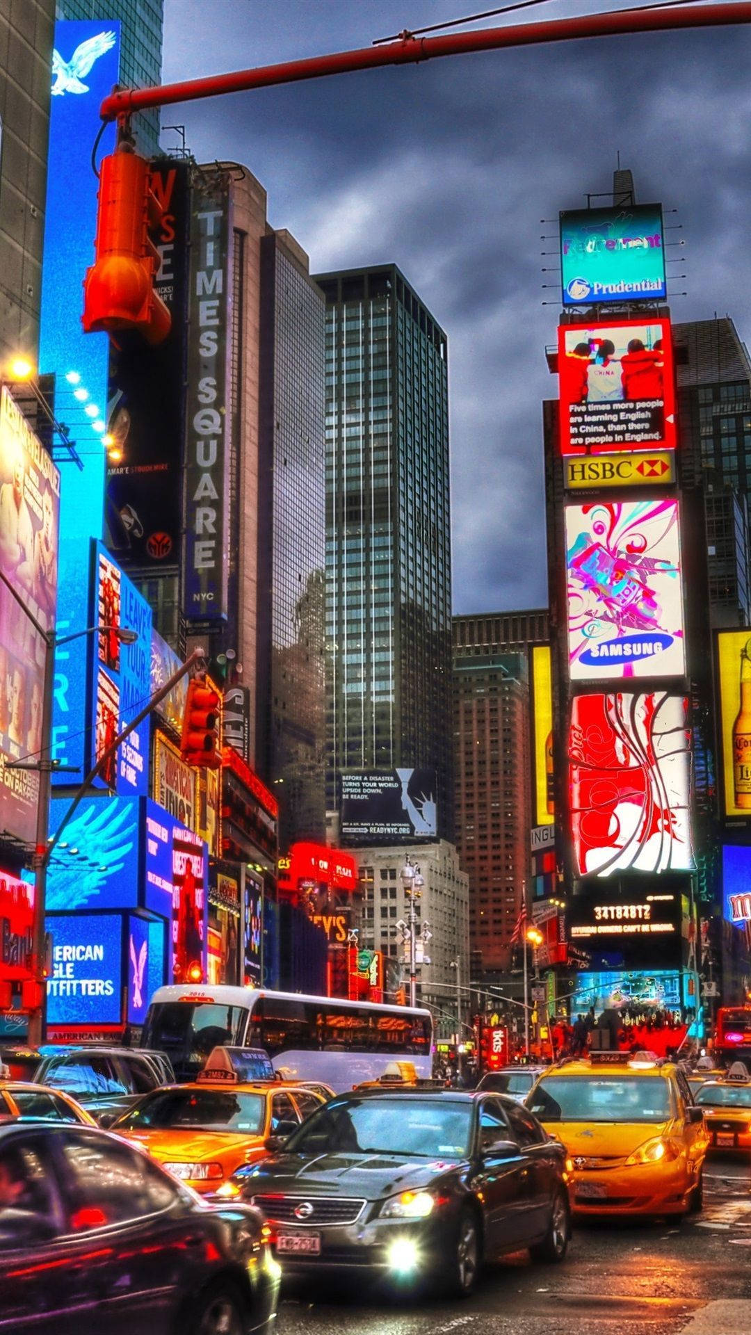 new york city iPhone x 桌布 壁紙 — 黃昏時分充滿活力的時代廣場，閃爍的廣告牌聳立在交通和行人之上。