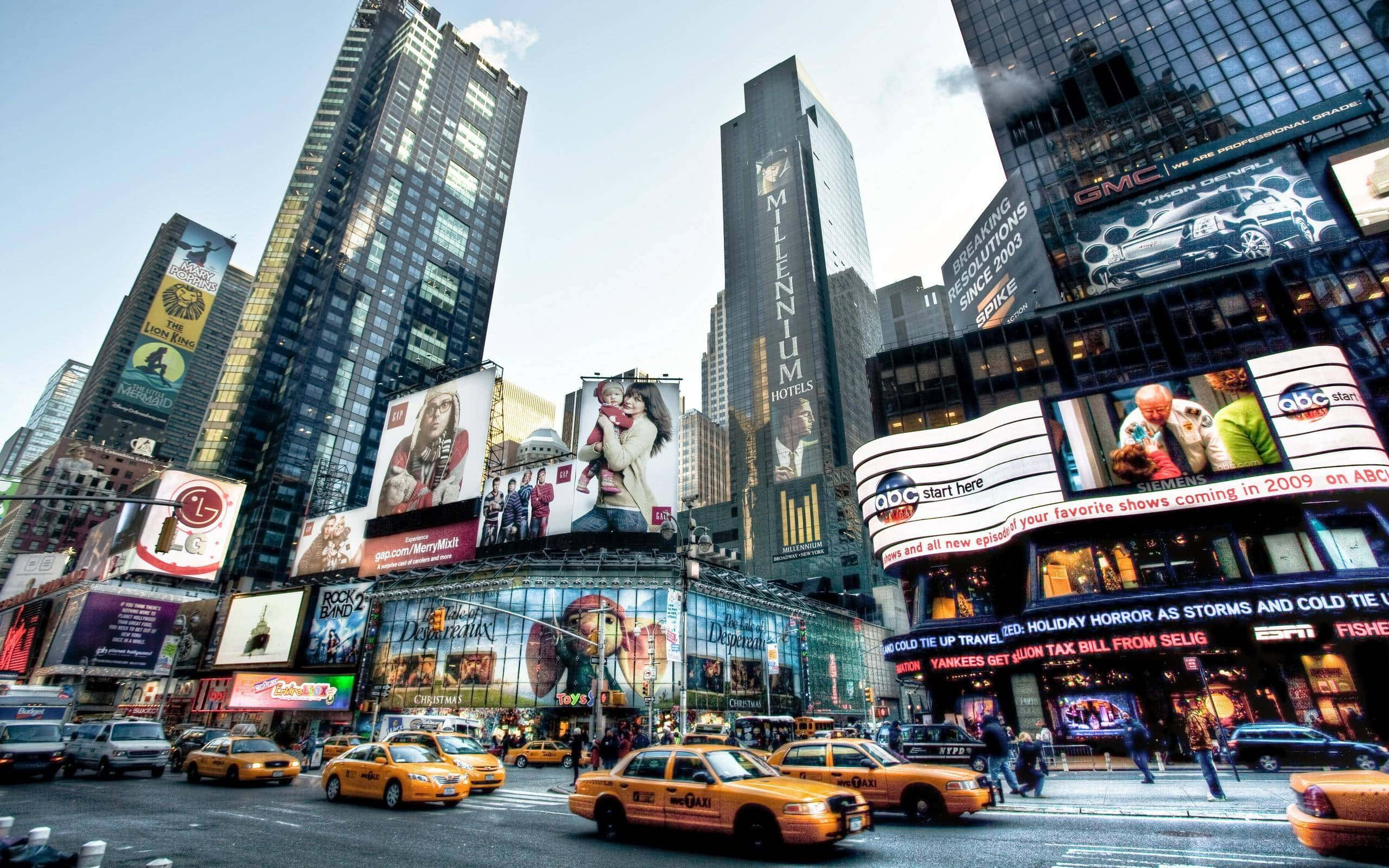 New York 桌布 壁紙 — 黃昏時分充滿活力的時代廣場，高聳的廣告牌在黃色的士和熙攘的人群上方閃耀。