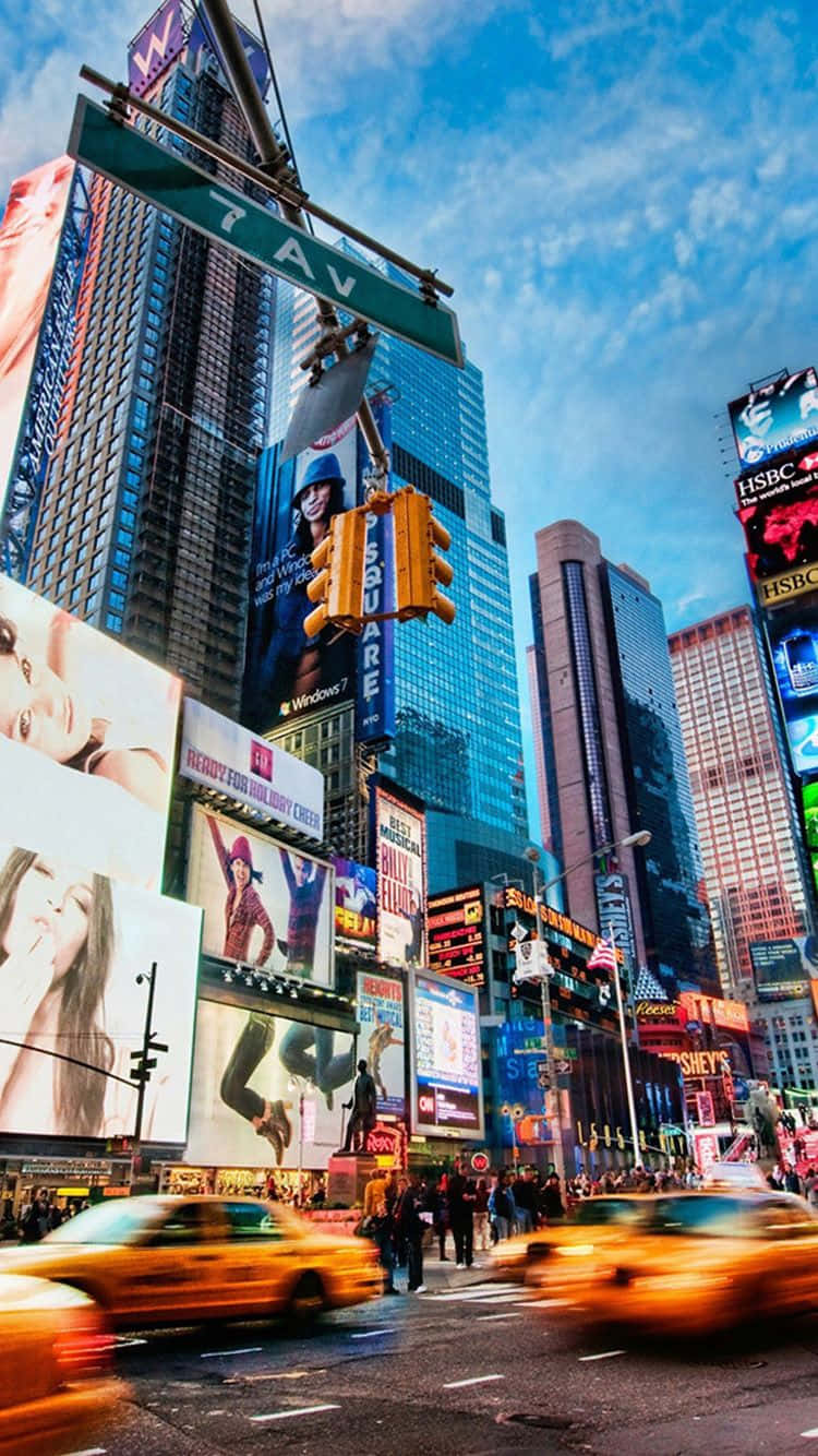 City iPhone 桌布 壁紙 — 黃昏時分充滿活力的時代廣場，高聳的廣告牌、閃爍的霓虹燈和飛馳而過的黃色計程車。