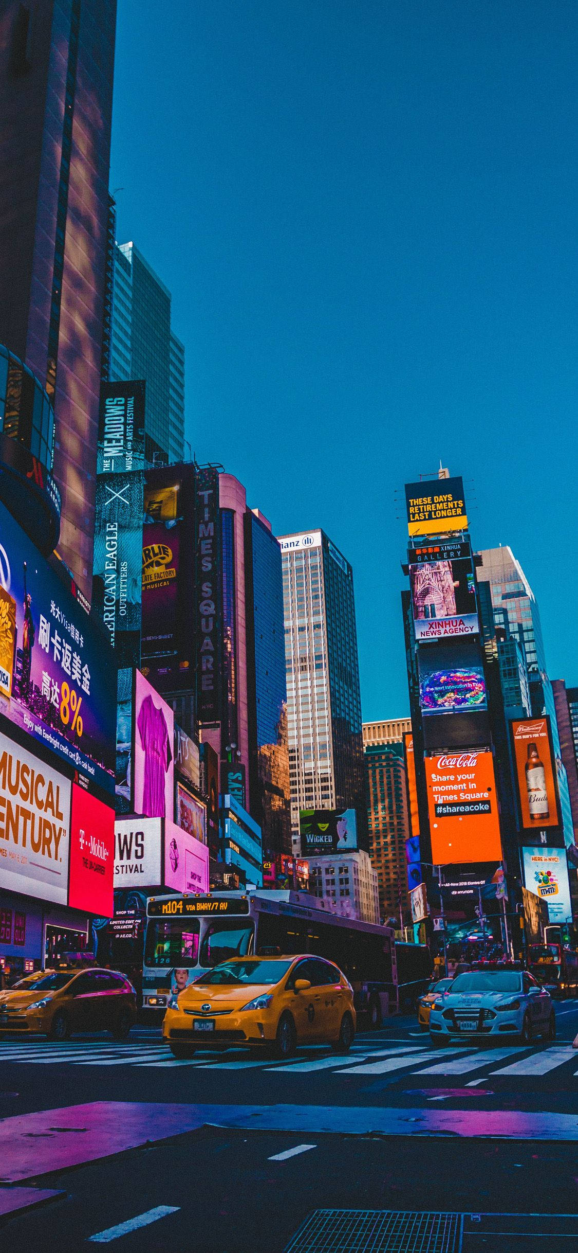 4K 桌布 壁紙 — 黃昏時分充滿活力的時代廣場，高聳的廣告牌閃爍著霓虹燈光，映照在濕漉漉的街道上，黃色的士穿梭於十字路口。