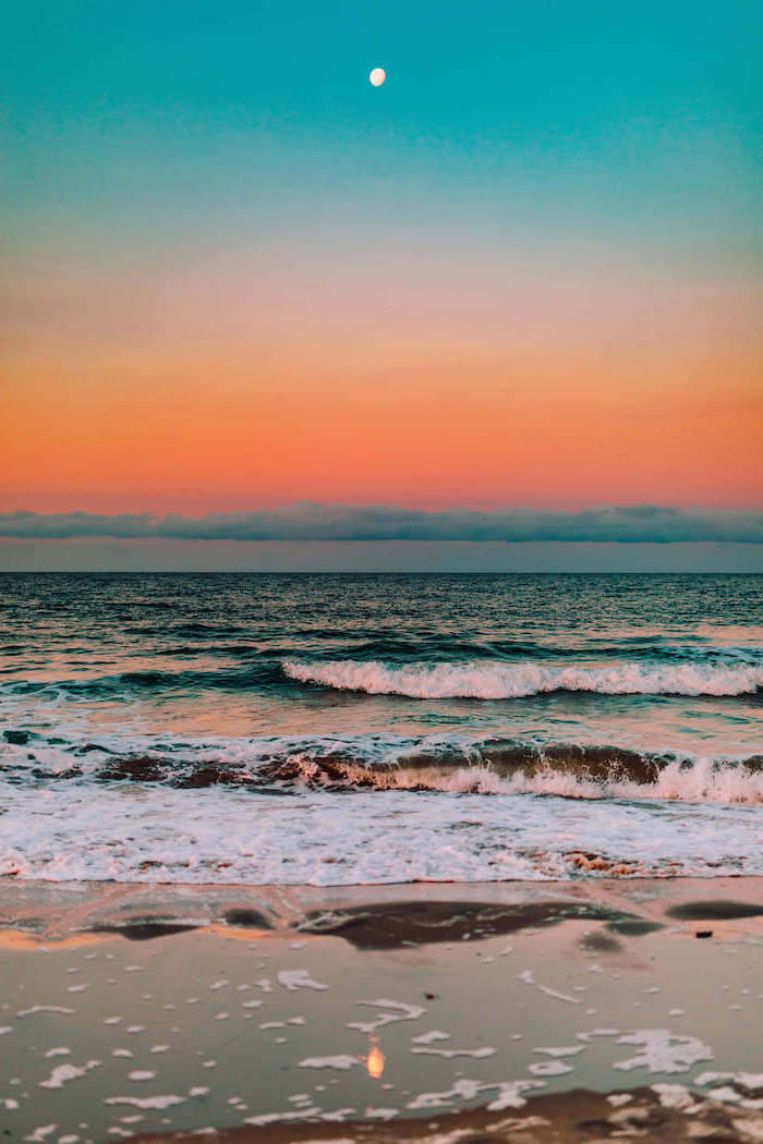 Pretty Aesthetic 桌布 壁紙 — 黃昏時分寧靜的海灘，在青綠色與橙色漸變的天空和可見的月亮下，溫柔的海浪拍打著海岸。