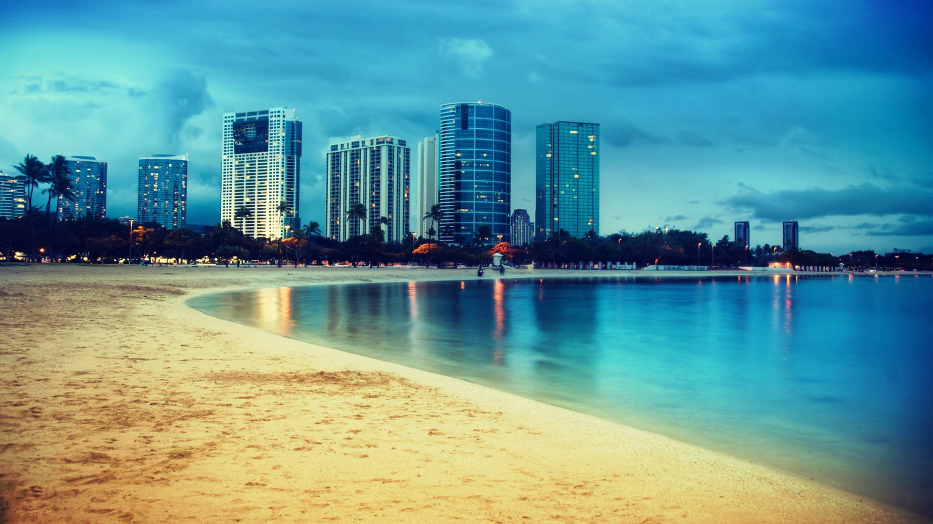 Miami 桌布 壁紙 — 黃昏時分寧靜的海灘，發光的城市摩天大樓倒映在平靜的碧綠海水中。