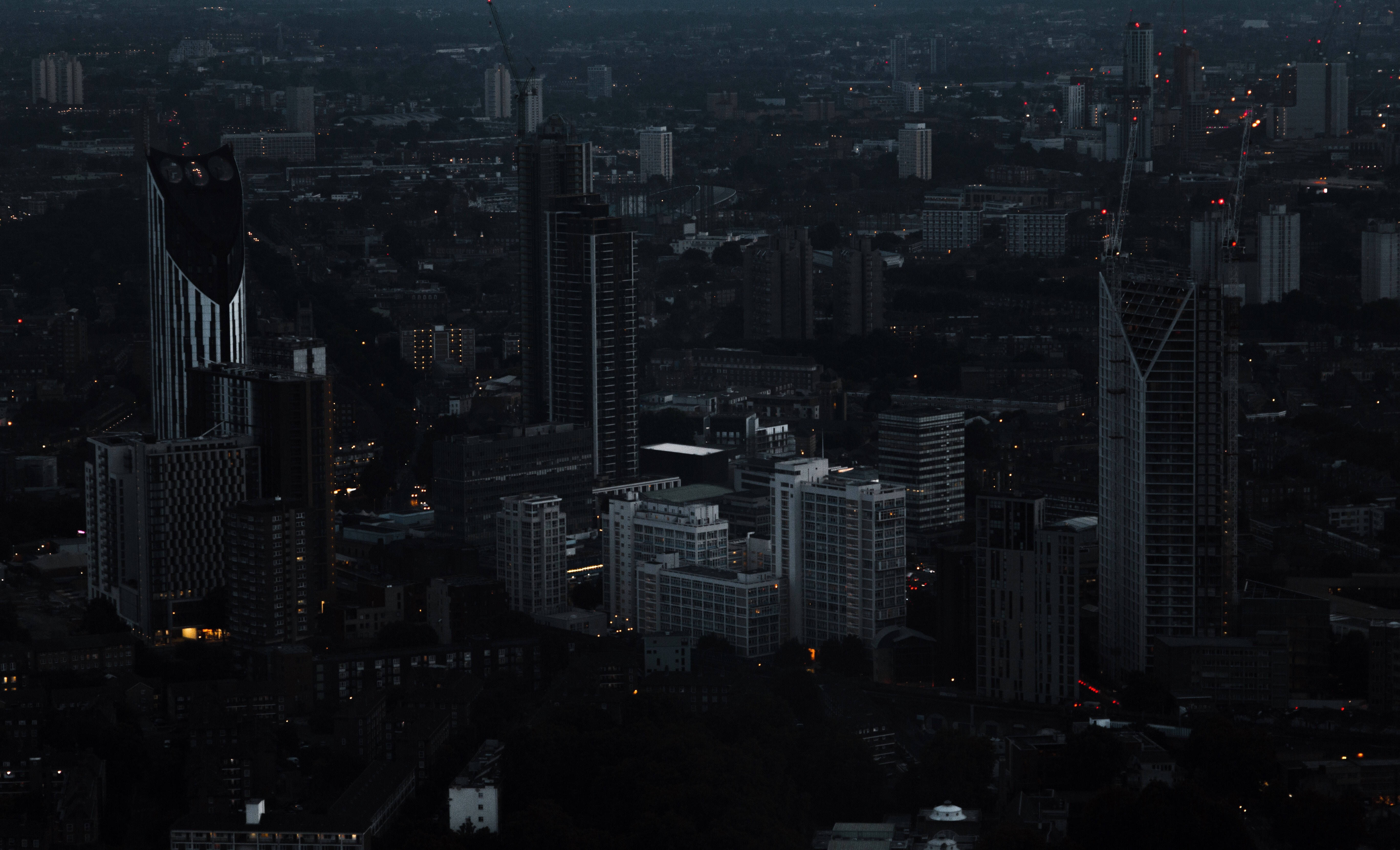 Skyscraper 桌布 壁紙 — 黃昏時分廣闊城市景觀的鳥瞰圖，高聳的摩天大樓在漸暗的光線中形成剪影，散落的窗戶閃爍著光芒。