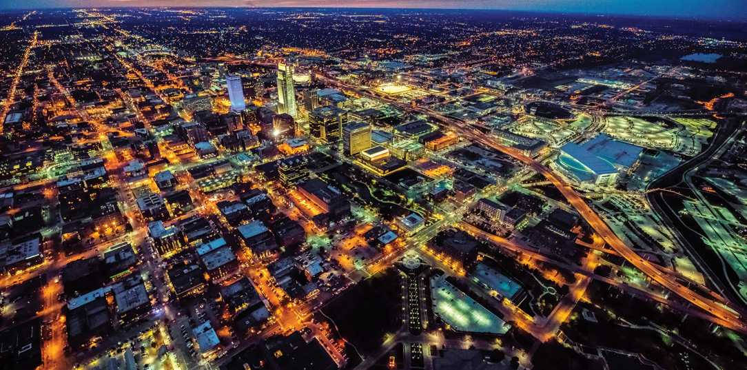 Nebraska 桌布 壁紙 — 黃昏時分廣闊城市的鳥瞰圖，發光的街燈和照亮的高樓大廈在城市景觀上投射出溫暖的光芒。