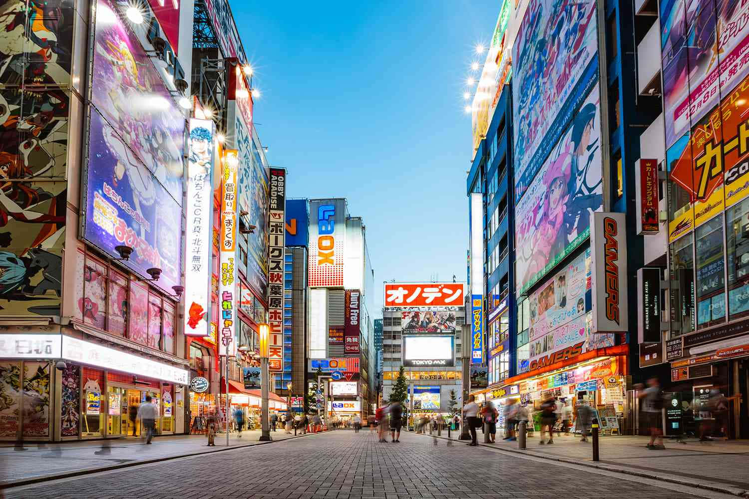 Tokyo Japan 桌布 壁紙 — 黃昏時分東京街頭霓虹燈閃爍，高聳的動畫廣告牌和熙攘的行人。