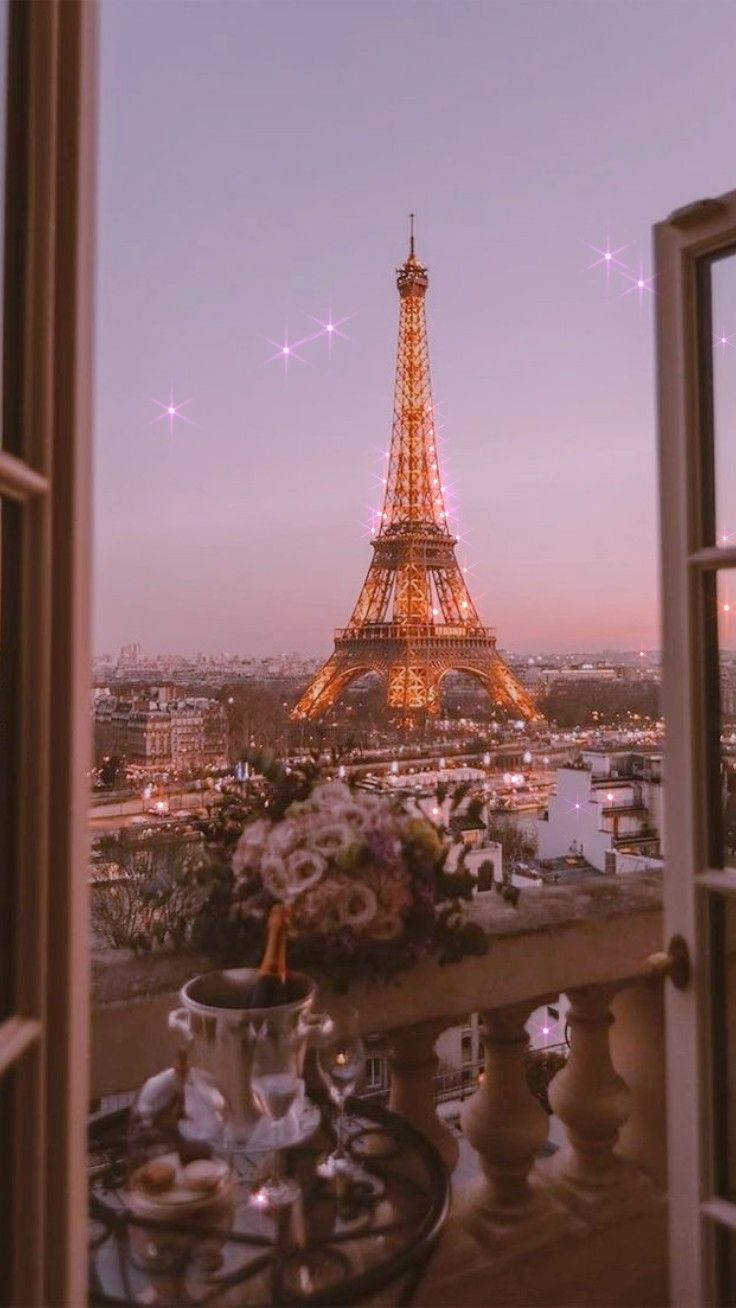 Eiffel Tower 桌布 壁紙 — 黃昏時分浪漫的巴黎陽台景觀，艾菲爾鐵塔溫暖發光，由打開的窗戶和閃爍的星星框住。