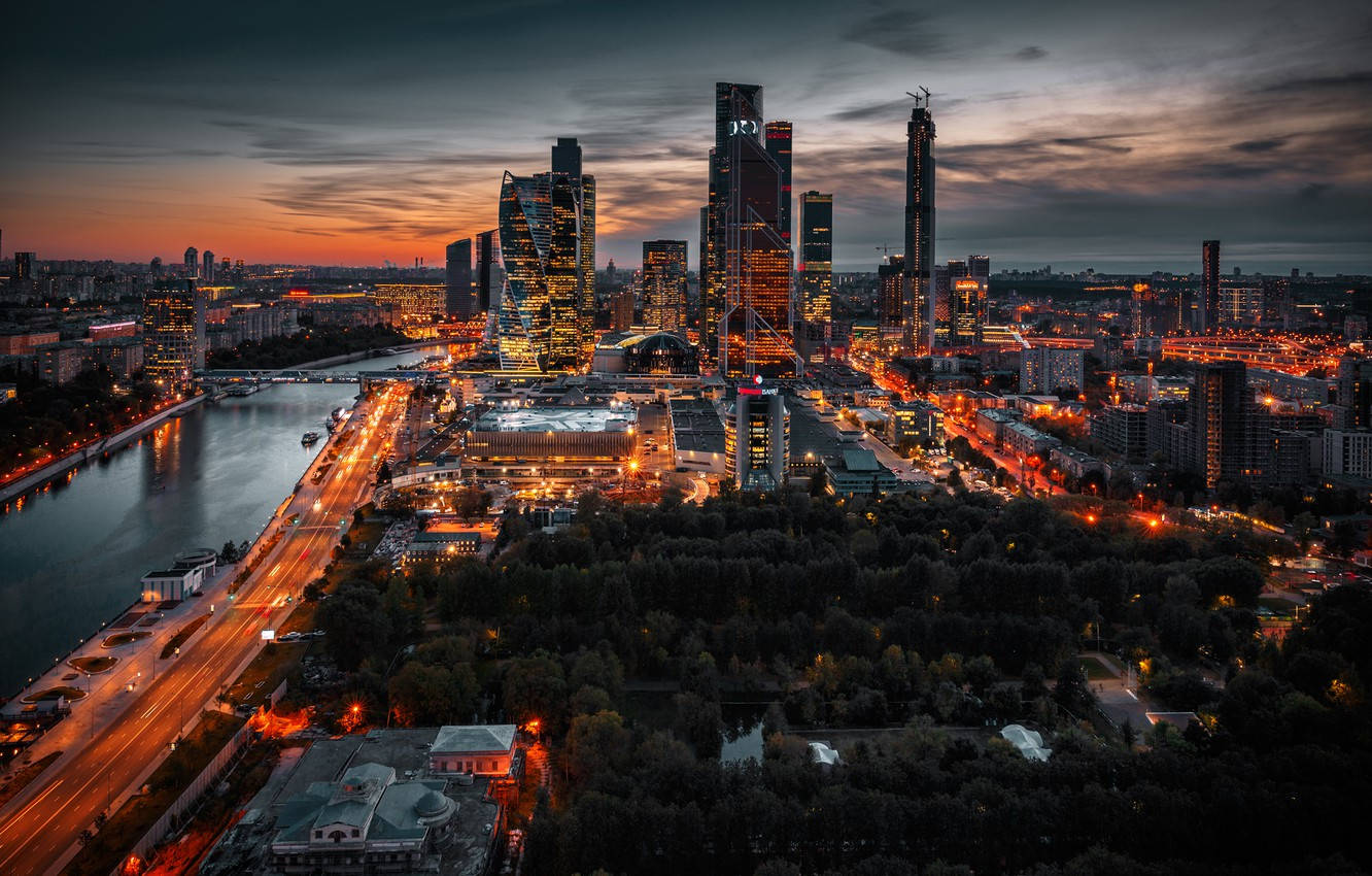 Moscow 桌布 壁紙 — 黃昏時分現代城市天際線的鳥瞰圖，閃爍的摩天大樓和反射溫暖燈光的河流。