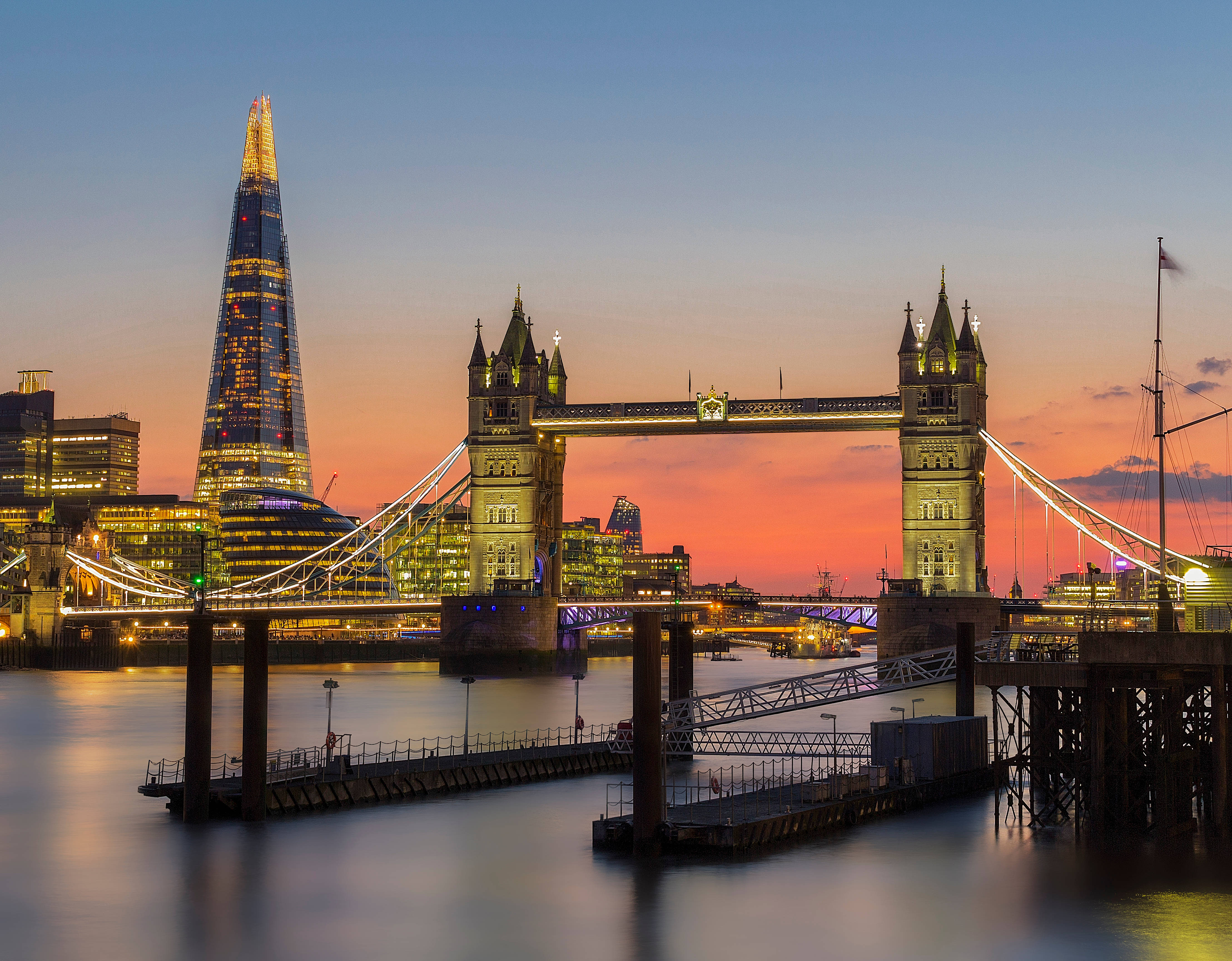 England 桌布 壁紙 — 黃昏時分的倫敦天際線，塔橋和碎片大廈在火熱的橙色和藍色天空下亮起。