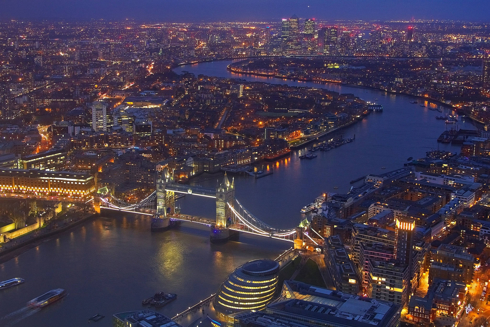United Kingdom 桌布 壁紙 — 黃昏時分的倫敦鳥瞰圖，泰晤士河上的塔橋被照亮，周圍是閃爍的城市燈光。