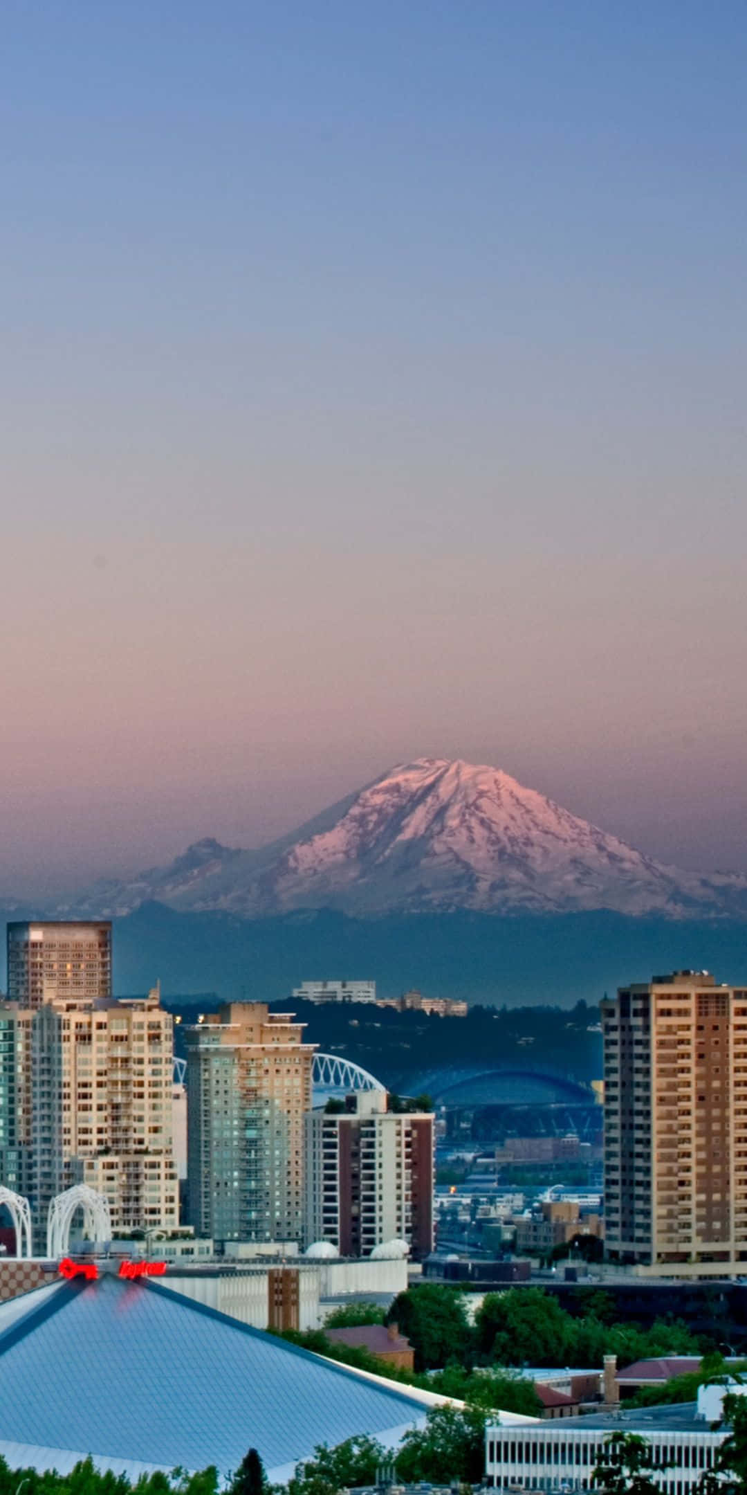 Pixel 3 Seattle 桌布 壁紙 — 黃昏時分的城市天際線，積雪的雷尼爾山在漸變天空映襯下閃耀著粉紅色光芒。