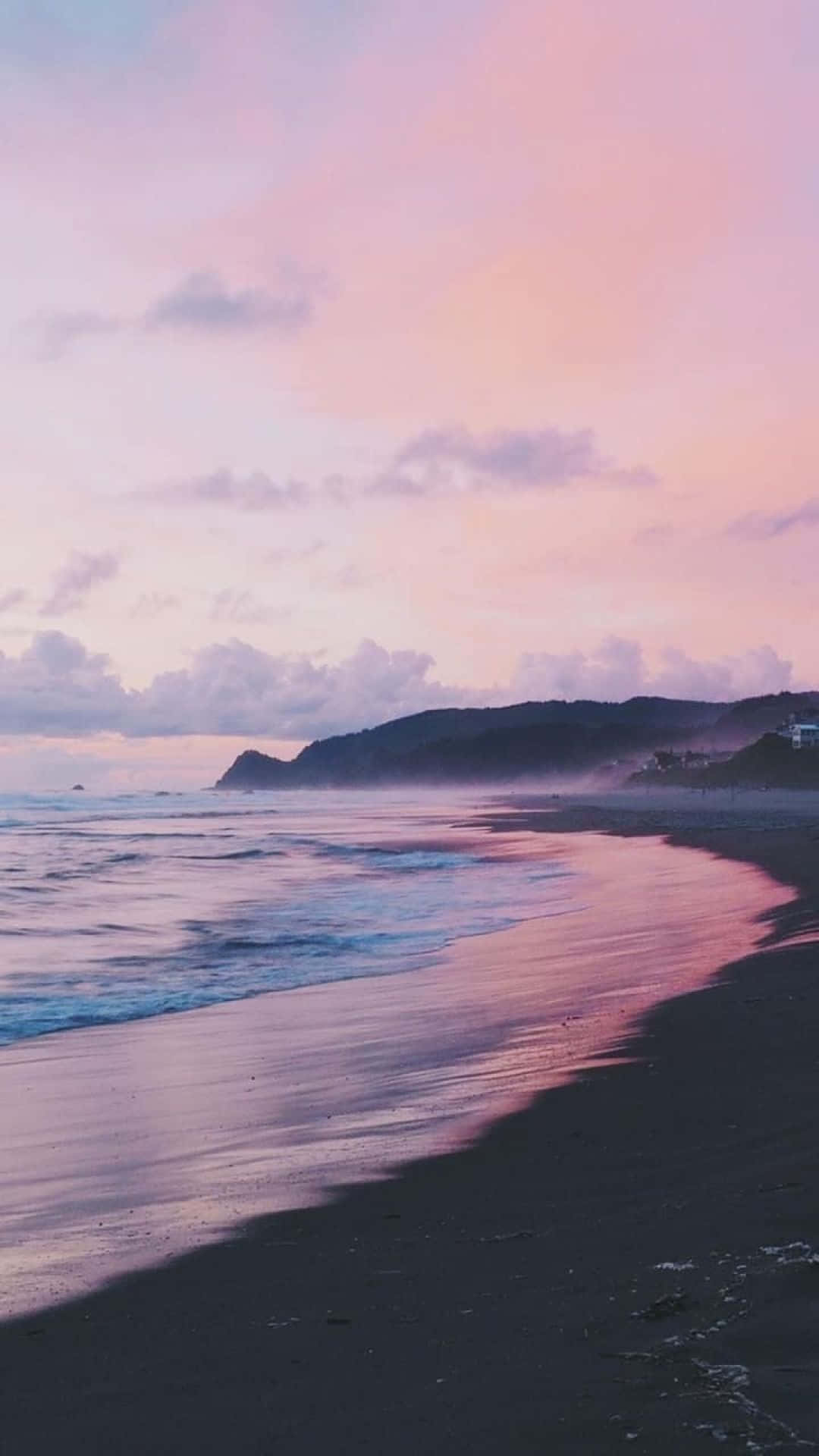 Beach Aesthetic 桌布 壁紙 — 黃昏時分的寧靜海灘，粉紅色和紫色的天空倒映在濕沙和輕柔的海浪上。