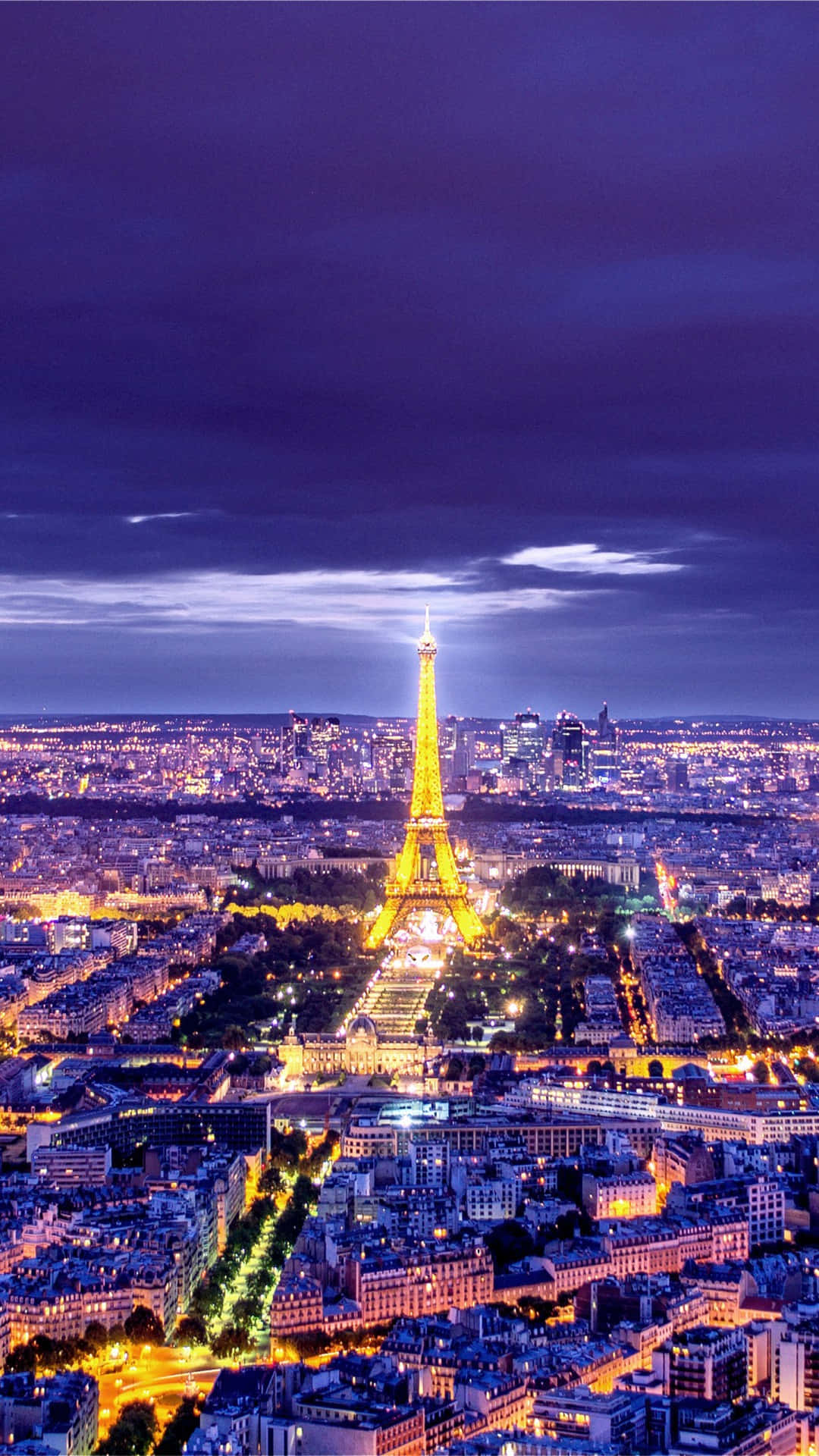 Paris Eiffel Tower 桌布 壁紙 — 黃昏時分的巴黎天際線，艾菲爾鐵塔在深紫色天空下閃耀著金色光芒。